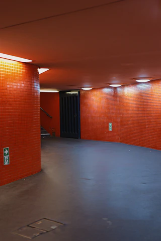 Orange tiled hallway with illuminated ceiling lights.