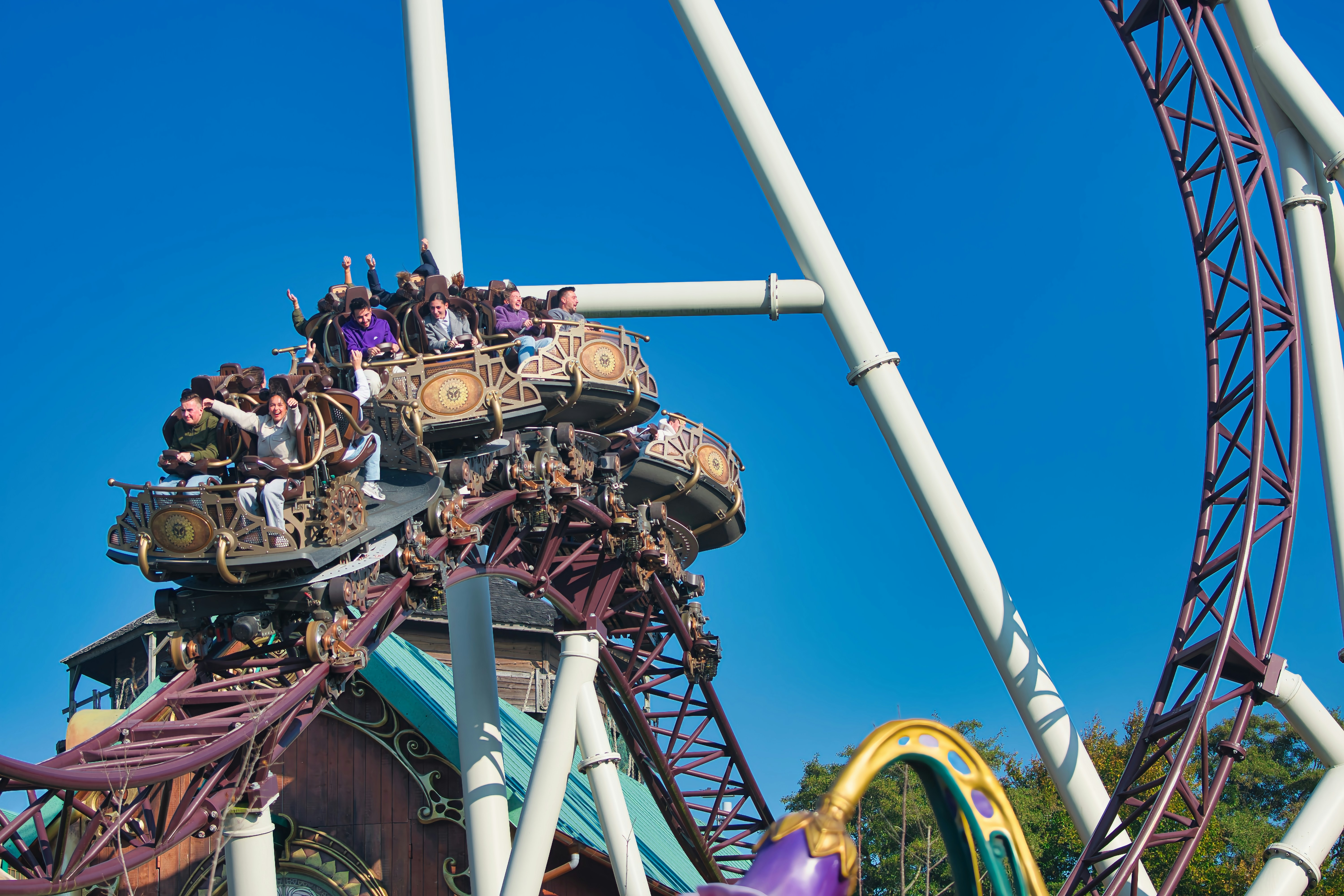 Pessoas andando em uma emocionante montanha-russa em um dia ensolarado