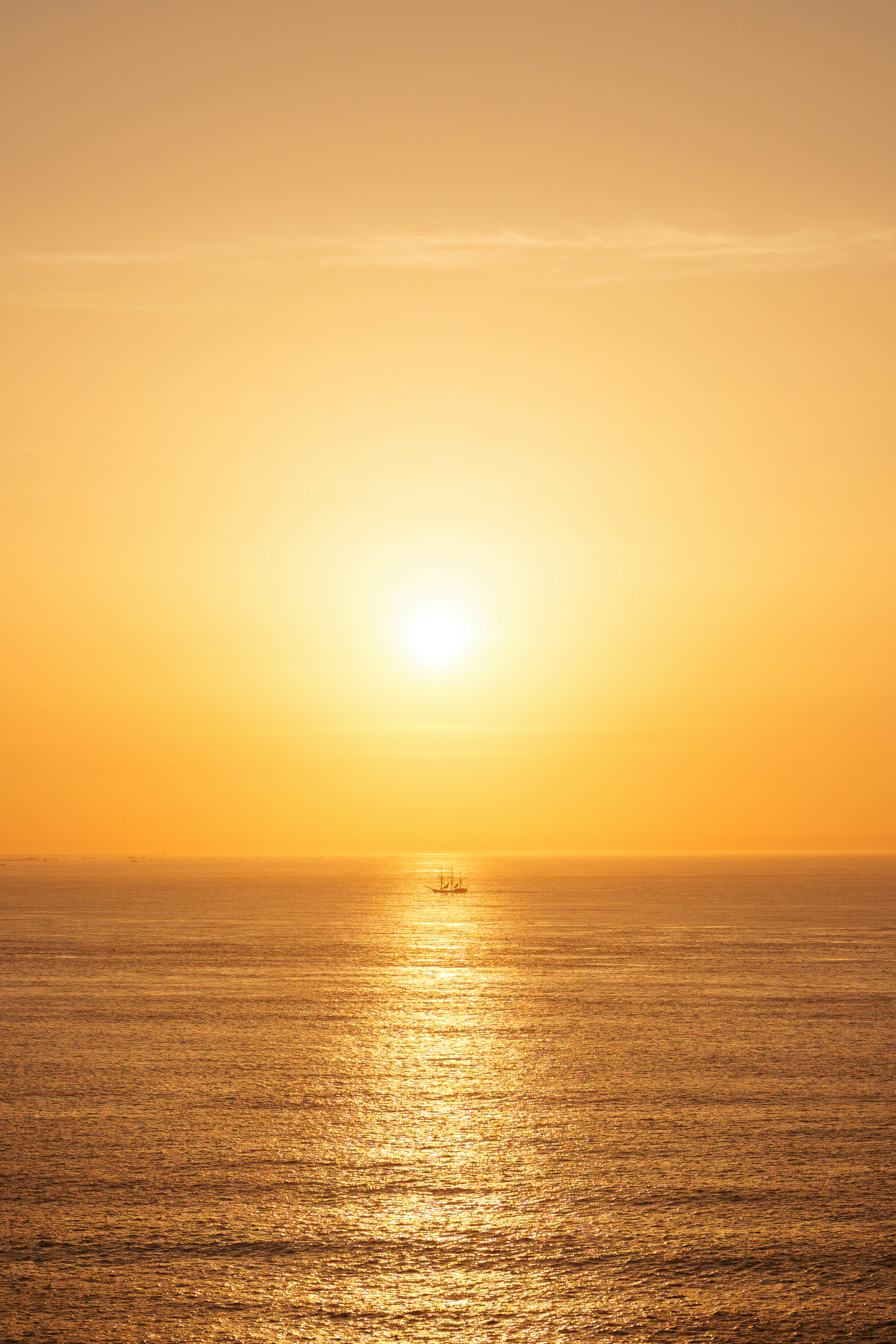 A small boat on the ocean at sunset.