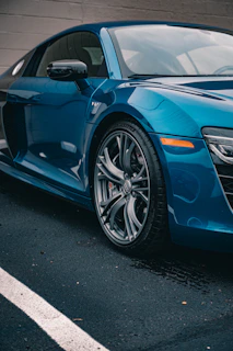 A sleek blue sports car parked on asphalt