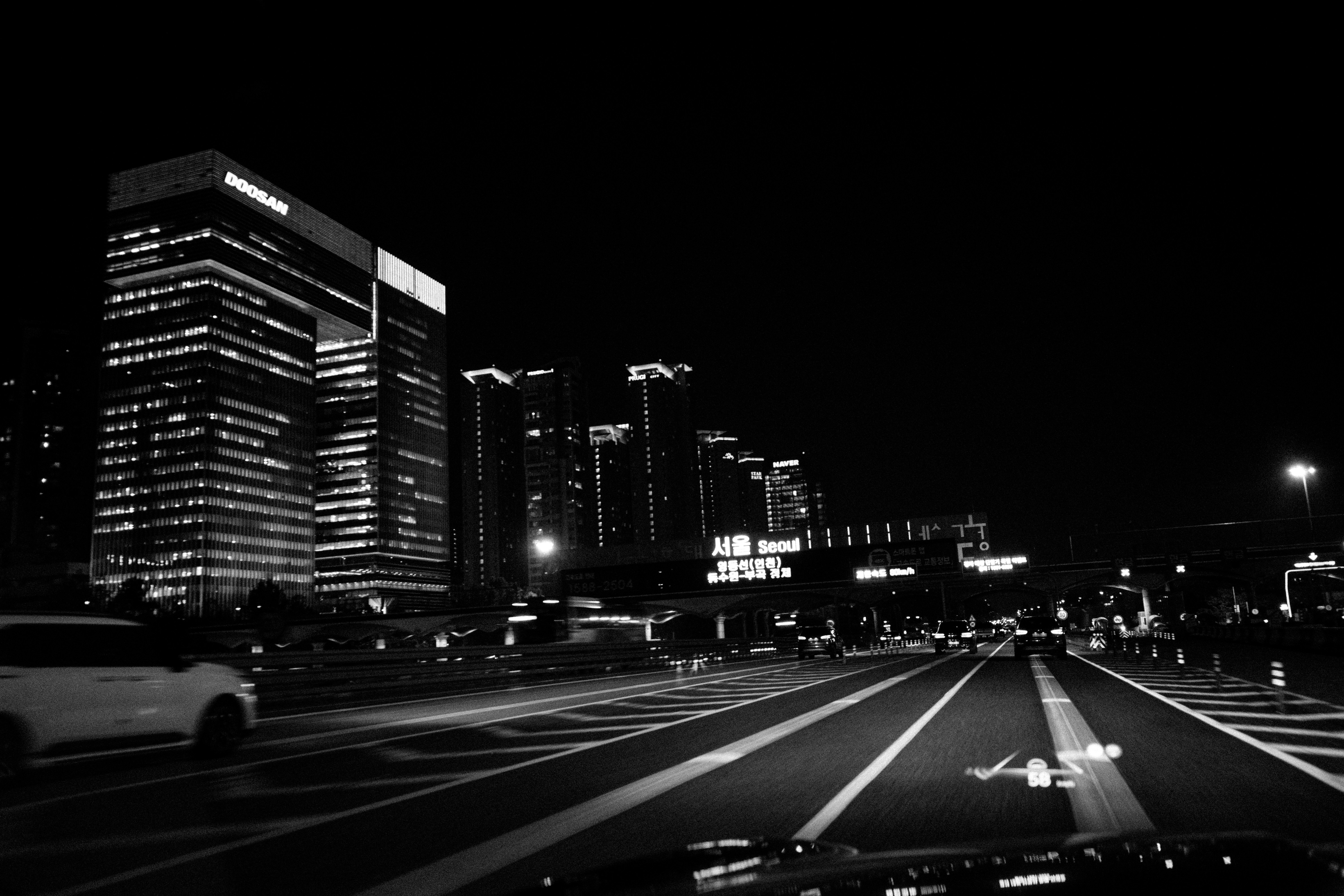 Cityscape at night with illuminated buildings and traffic.