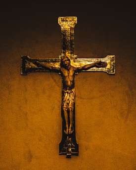 A golden crucifix with jesus on a textured background