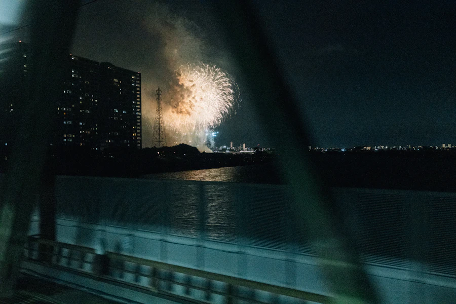 Large colorful fireworks bursting over a river at night in Japan