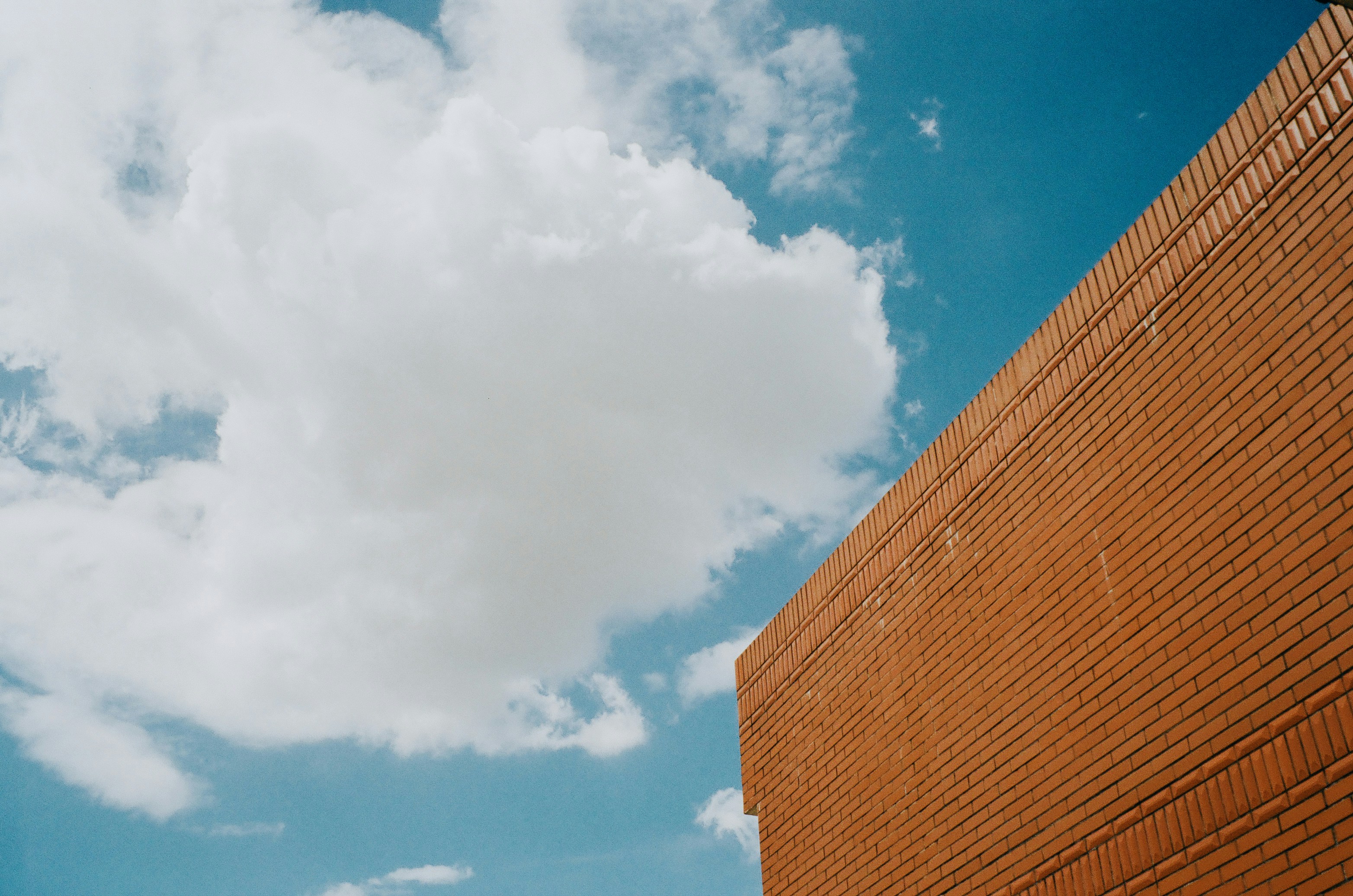Brick wall against a cloudy blue sky