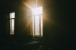 Sunlight streams through a window into a dark room.