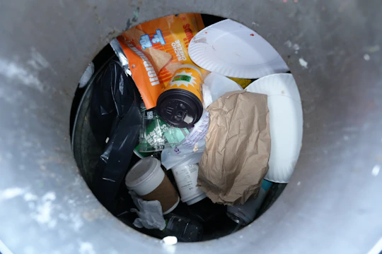 Trash can filled with various discarded items.