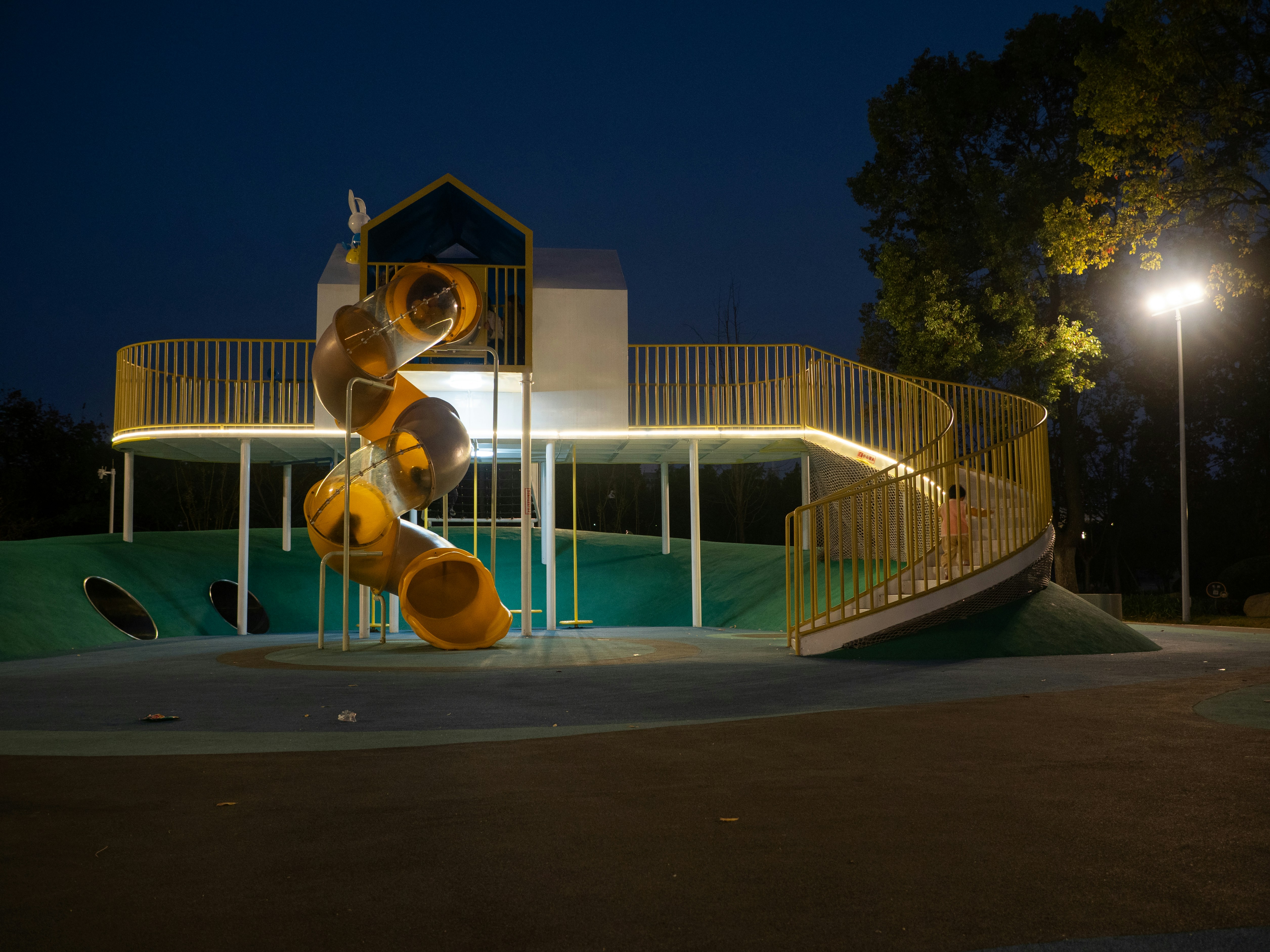 Equipamiento moderno de parque infantil iluminado por la noche