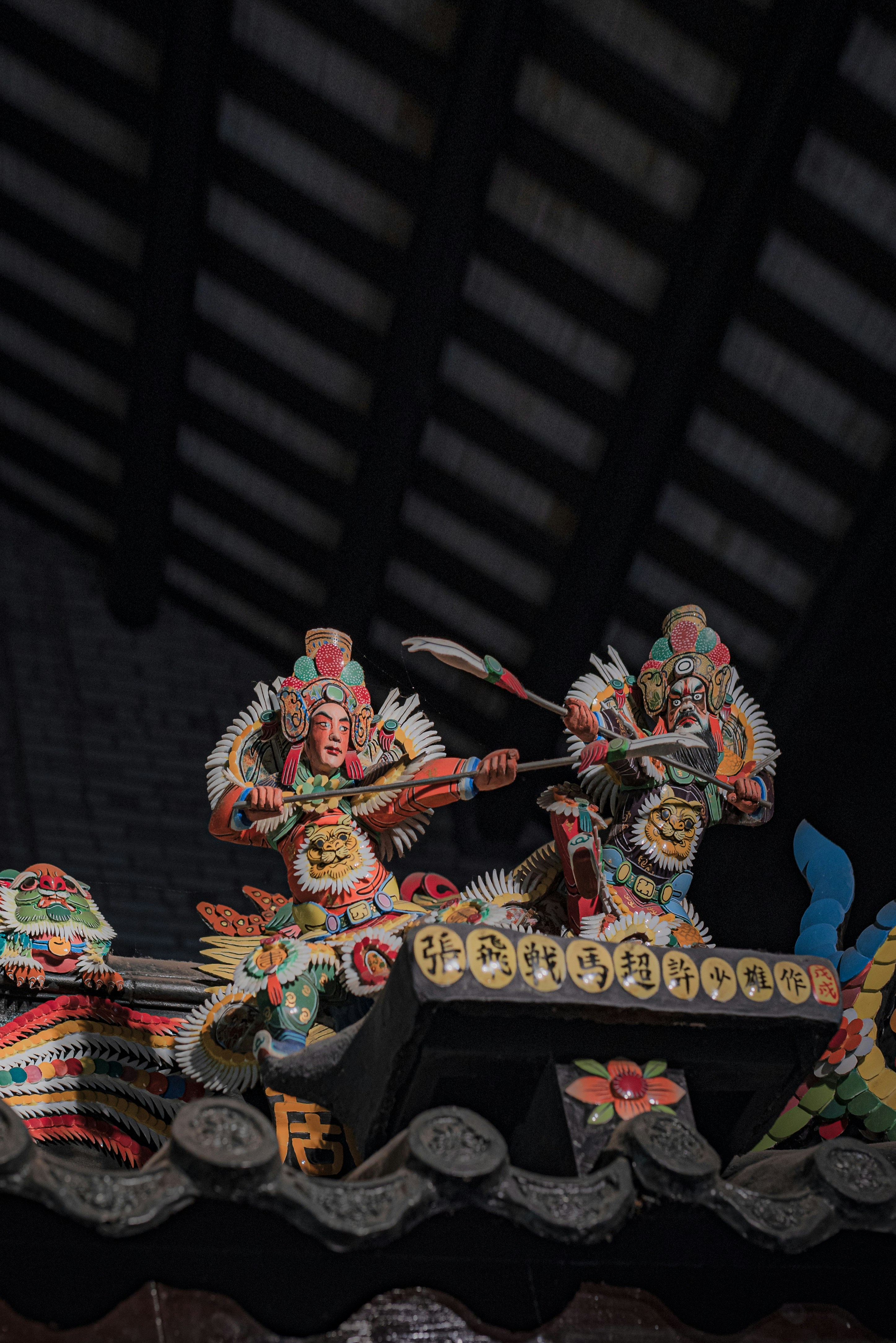 Colorful roof figurines depict warriors in combat.