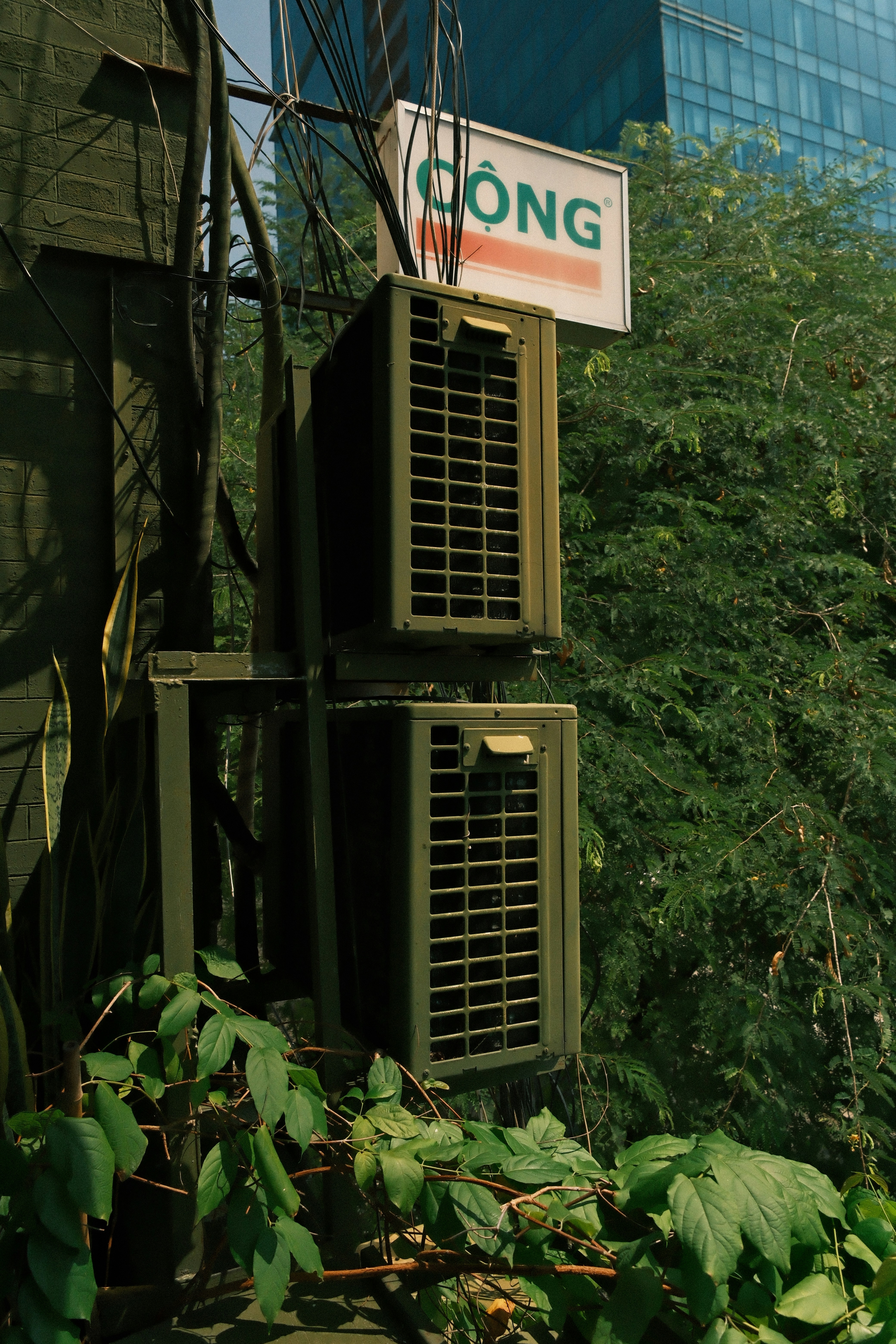 Two outdoor air conditioning units on a wall.