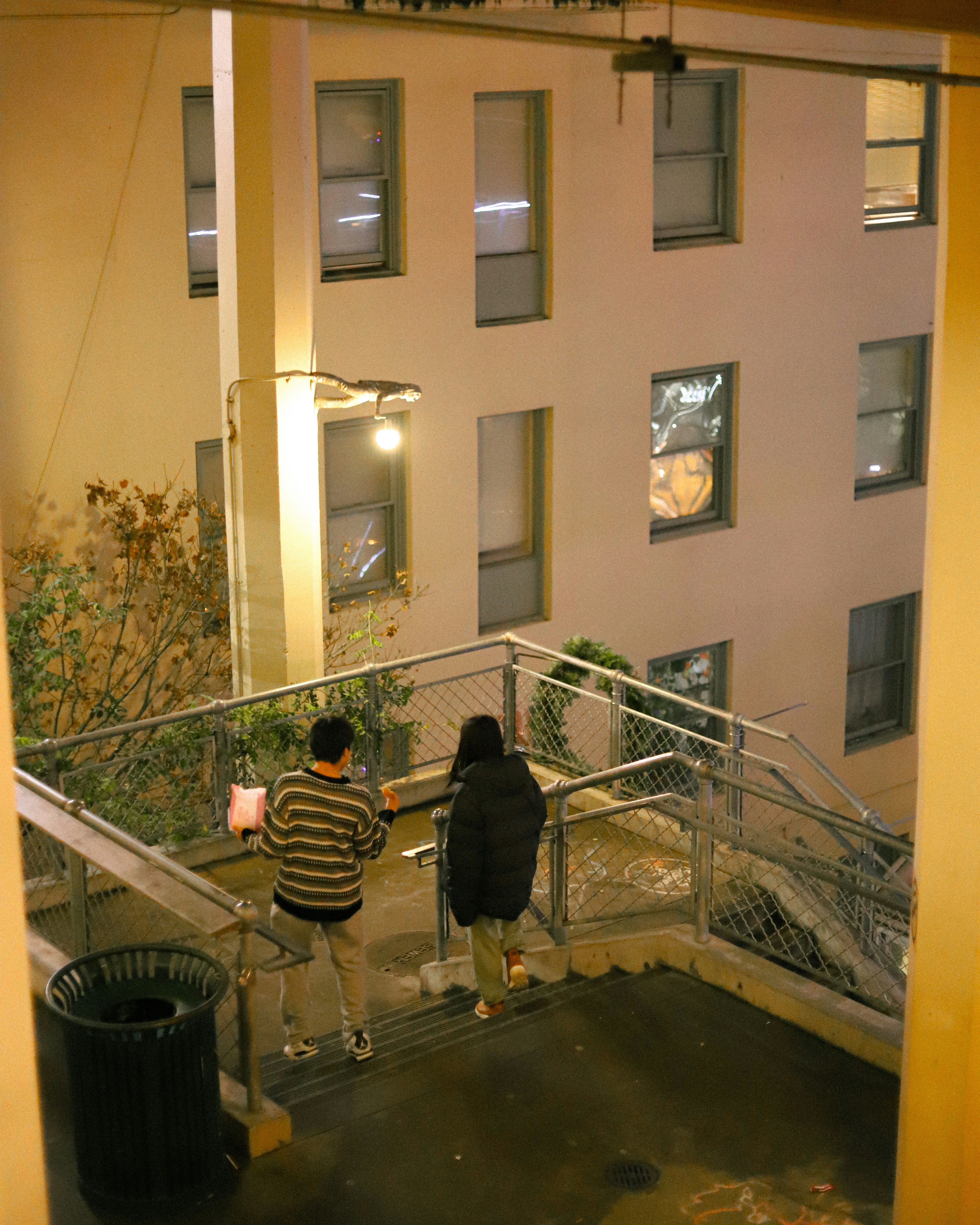 Zwei Personen auf einer Außentreppe in der Nacht