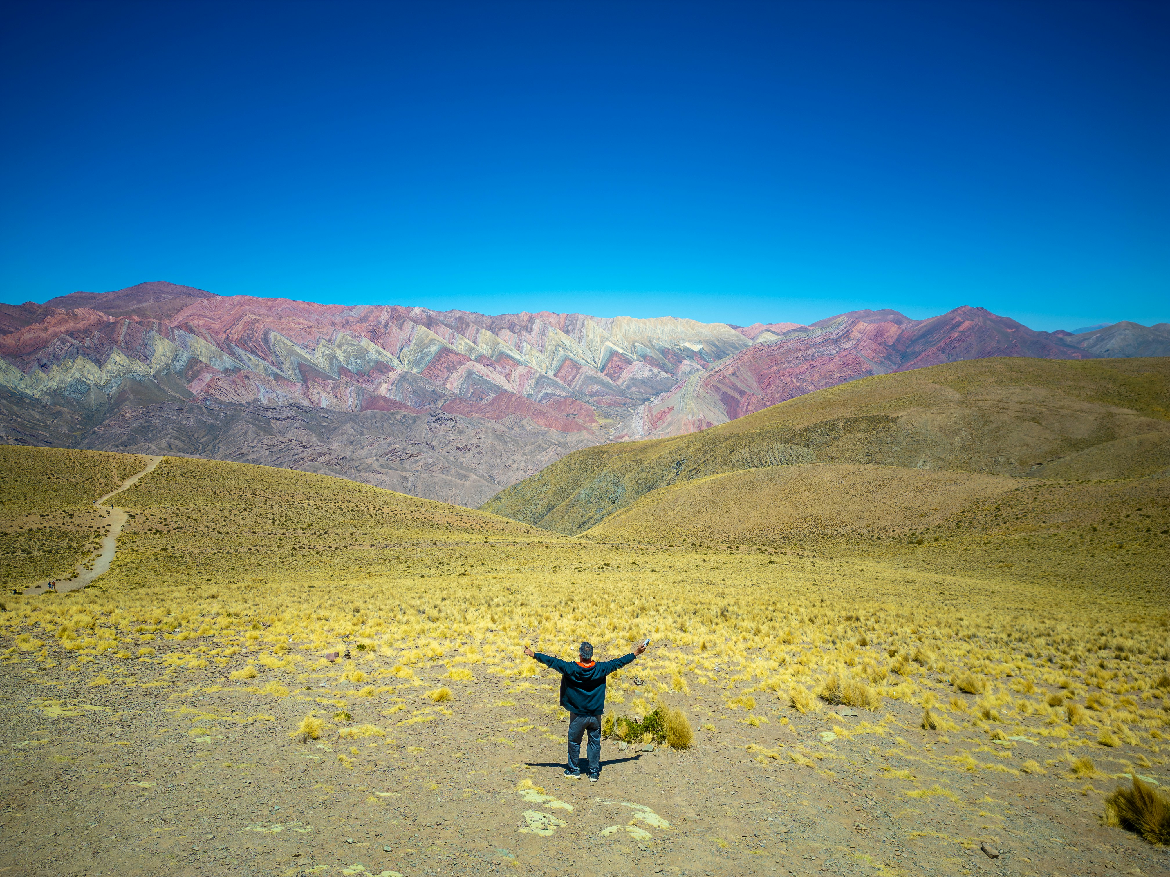 uomo con le braccia tese nel colorato paesaggio montano.