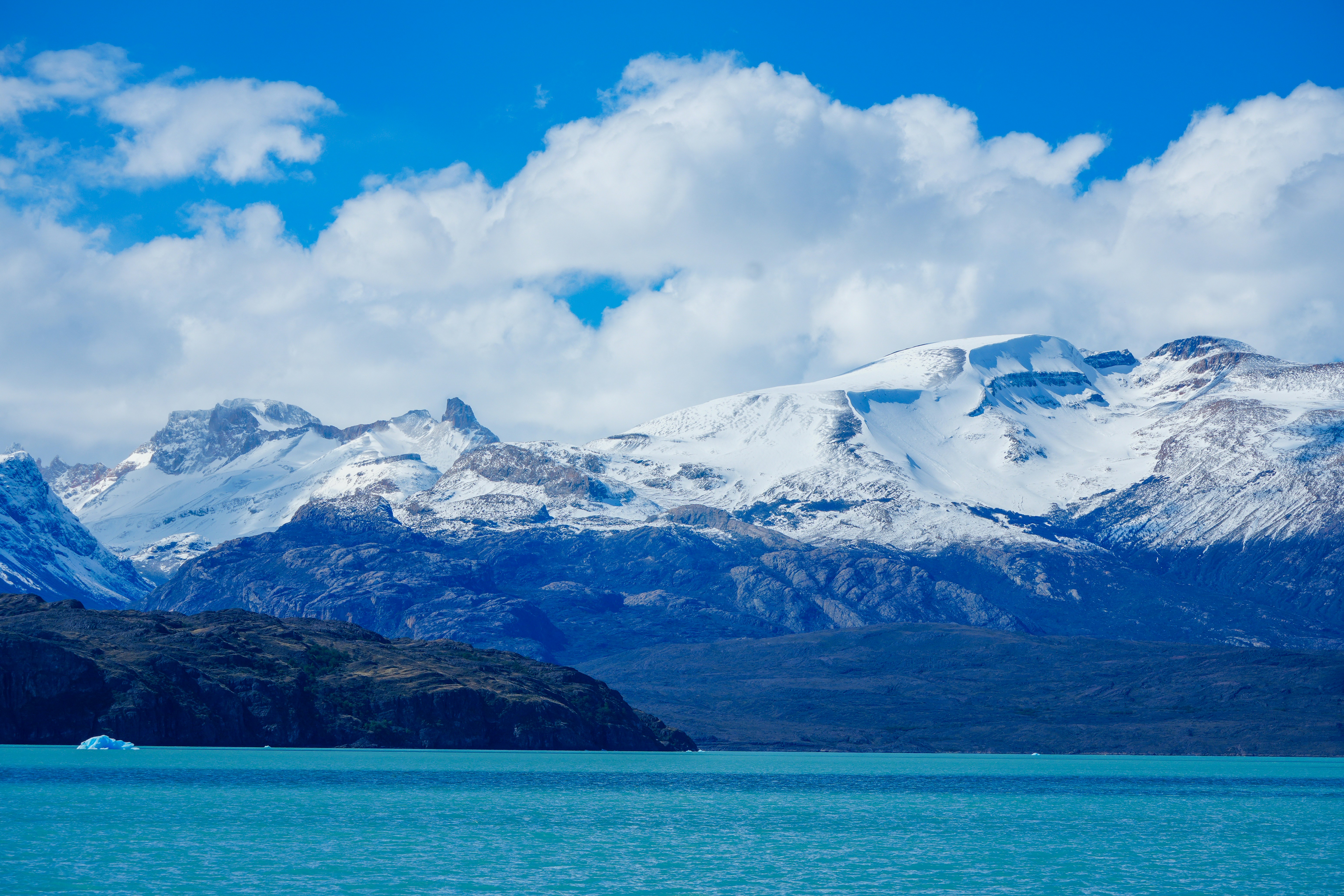 Snow-capped mountains rise above a blue lake