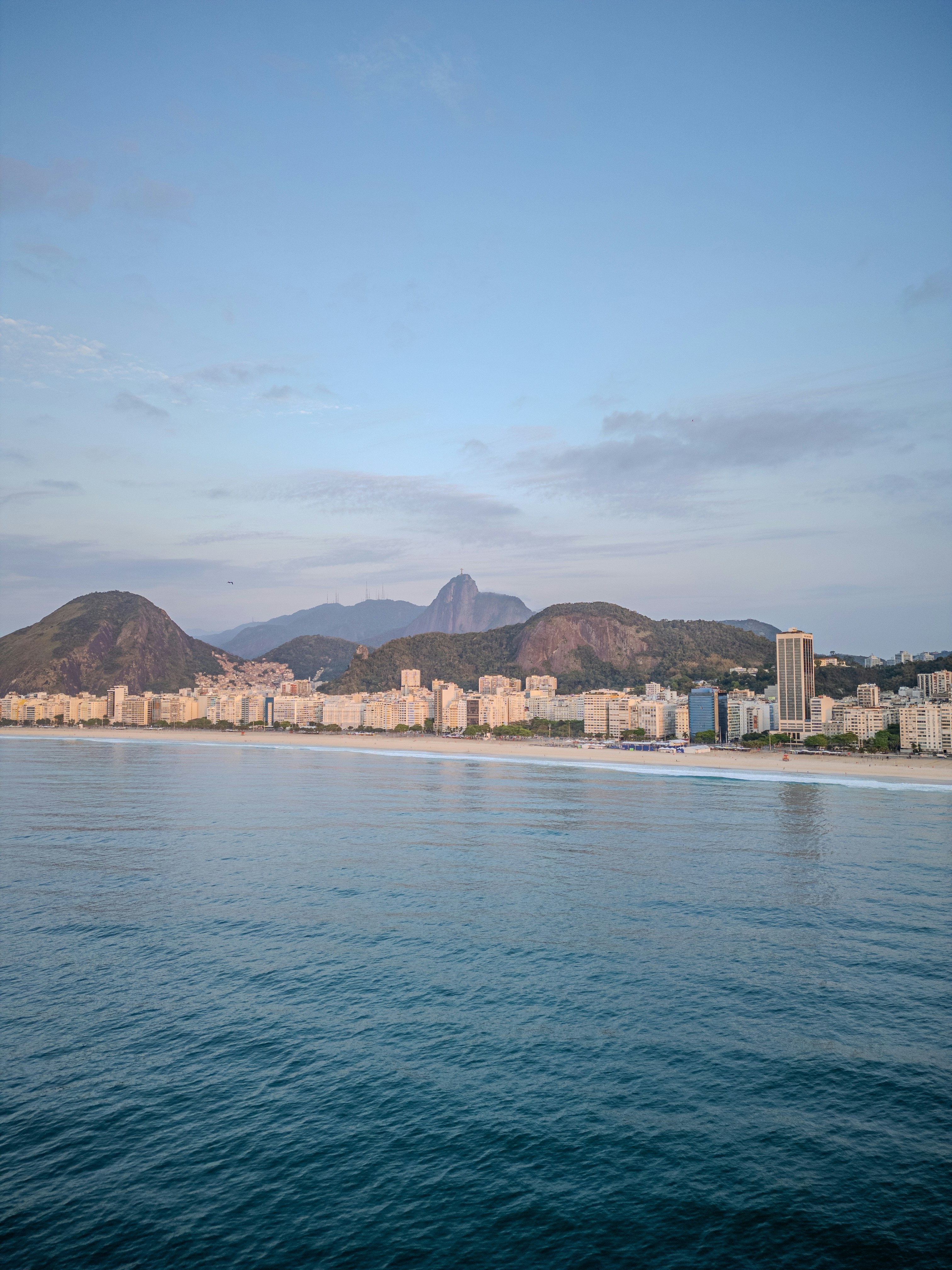 Skyline della città costiera con montagne e oceano.