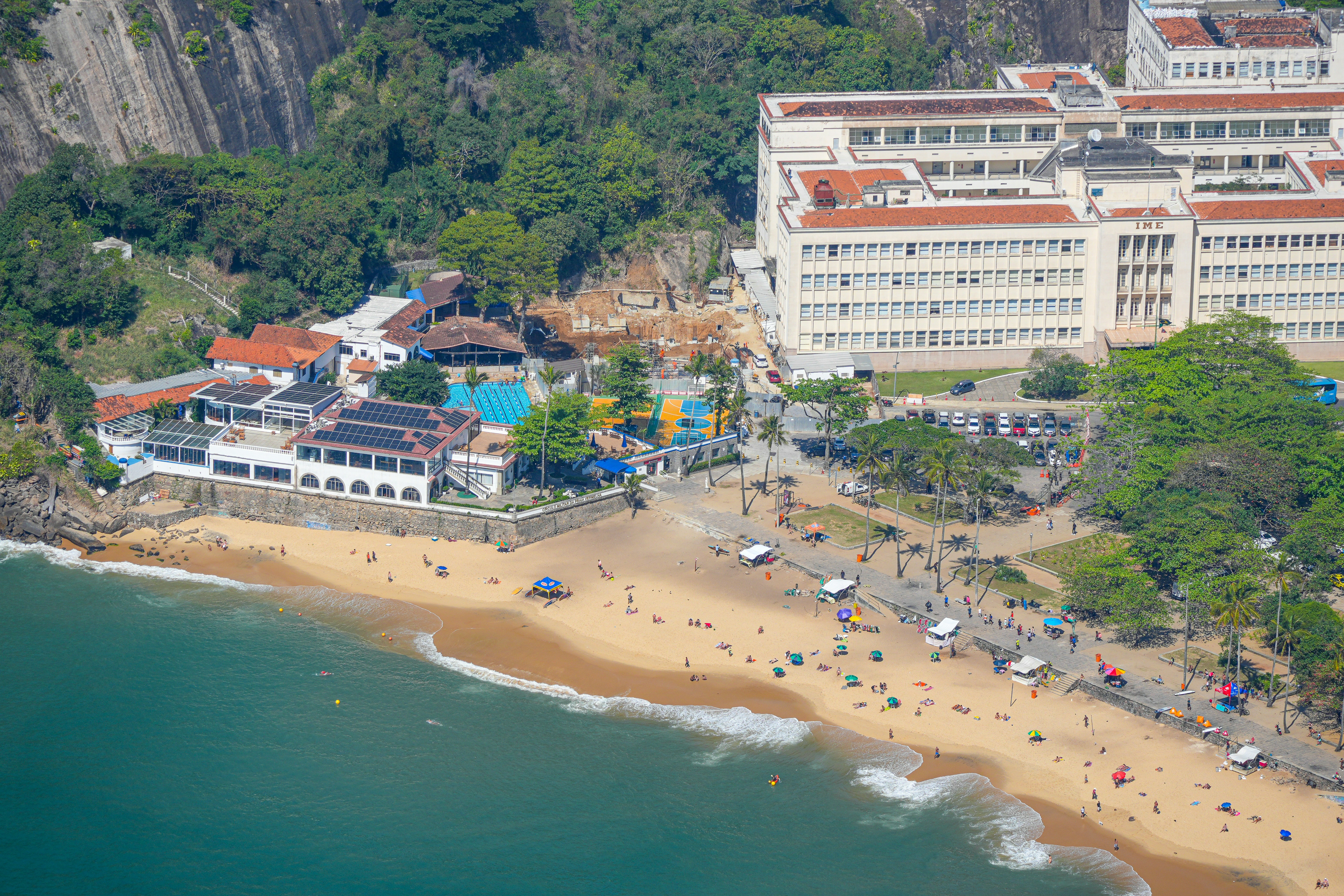 Resort sulla spiaggia con piscina vicino all'oceano e agli edifici.