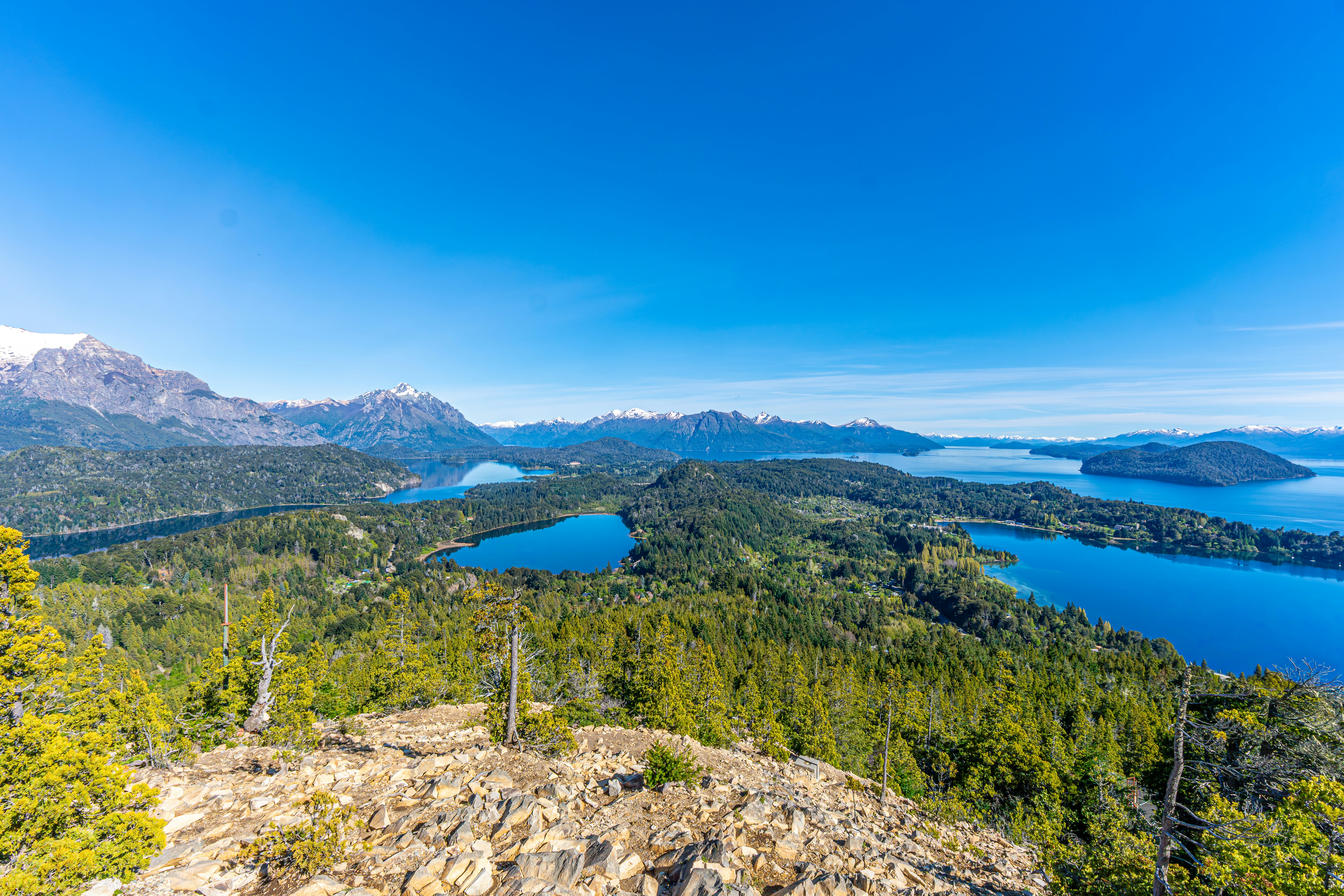 Lussureggianti montagne verdi circondano laghi blu sotto il cielo limpido.