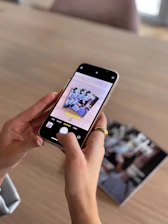 Hands holding phone taking picture of photos