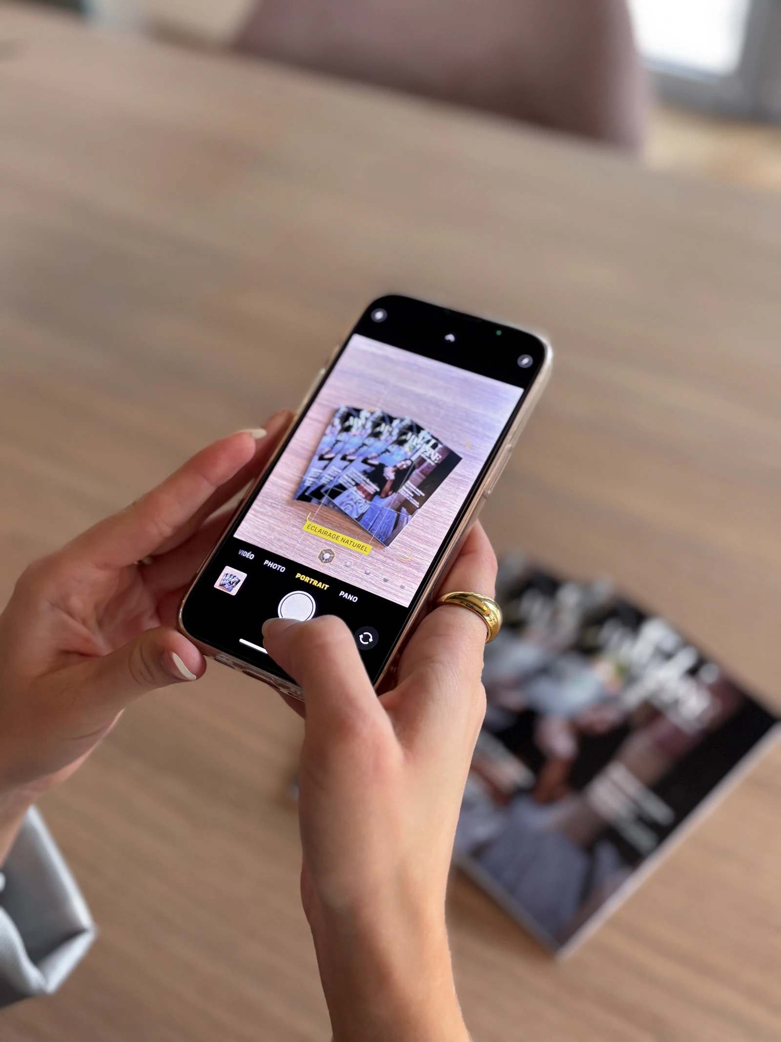 Hands holding a phone to photograph a spread of printed photos
