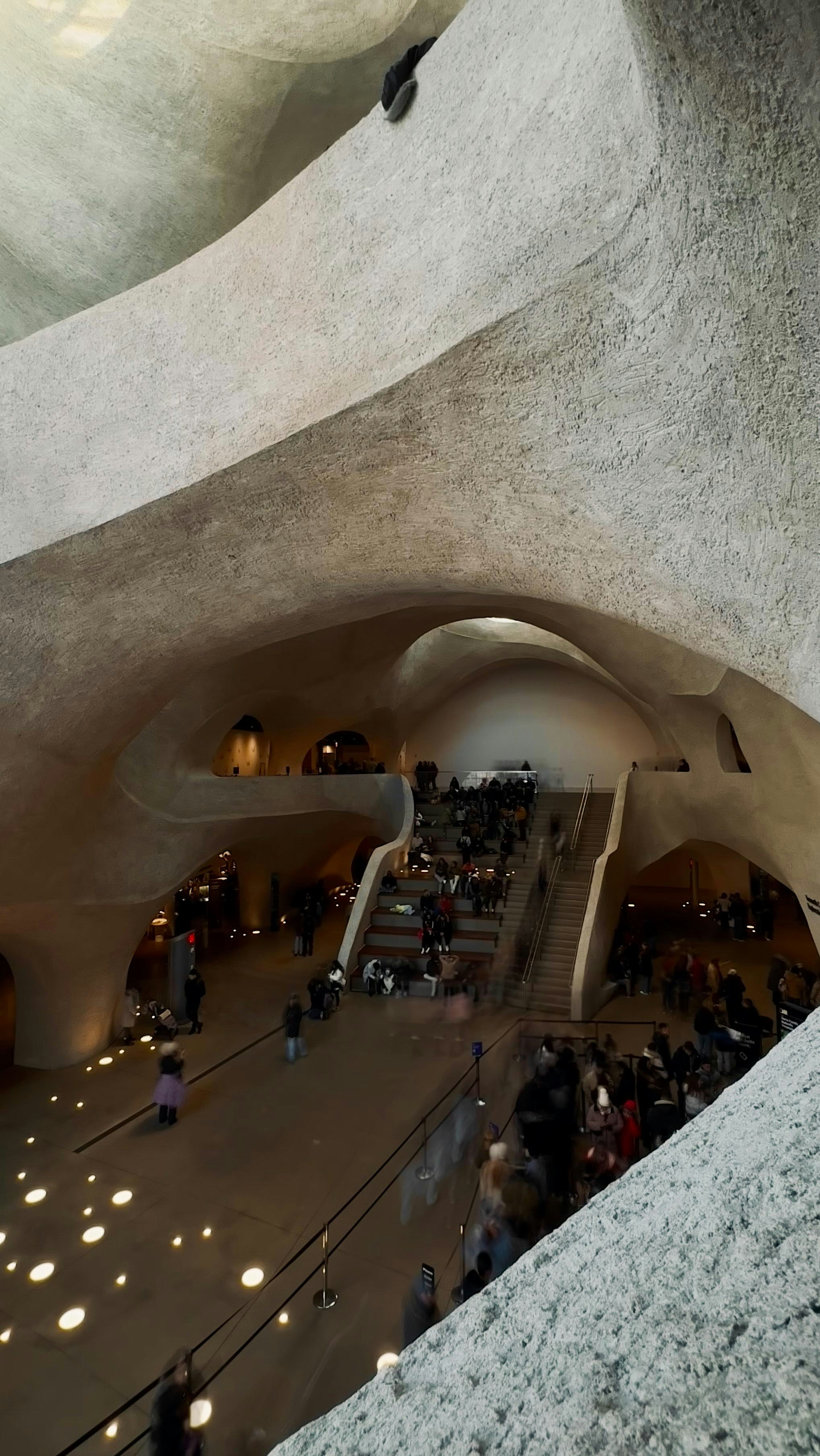 People gathered inside a modern, organic-shaped building.