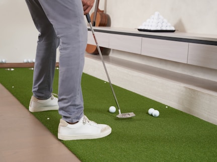Man playing indoor mini golf with white balls
