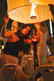 Woman holding a lit lantern at night