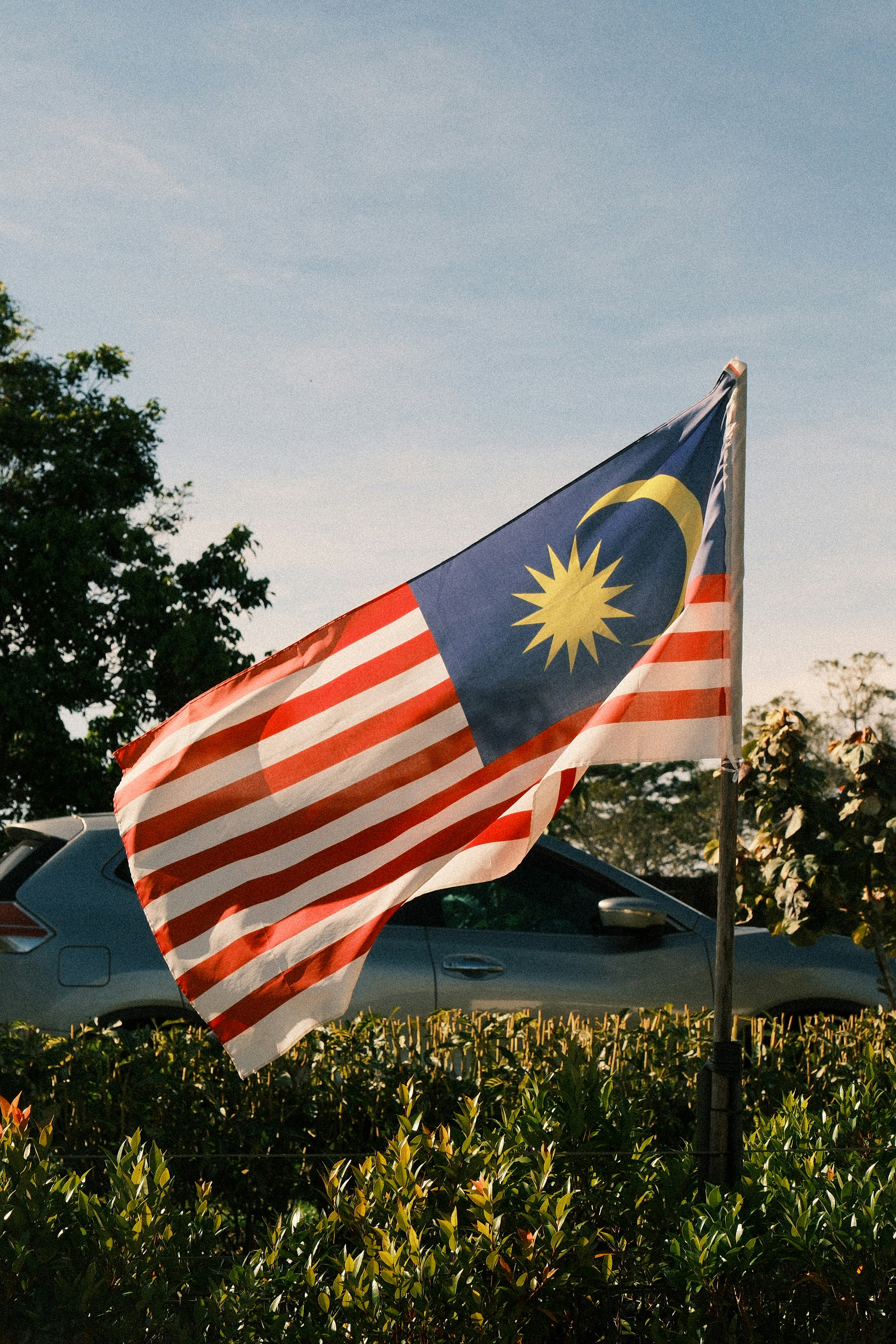 Malaysian flag waving in the wind outdoors.