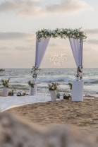 Wedding arch decorated with flowers on a beach.