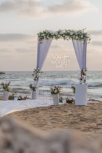 Wedding arch decorated with flowers on a beach.