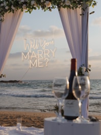 Marriage proposal setup on a beach at sunset.