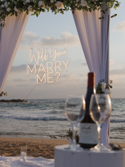 Marriage proposal setup on a beach at sunset.