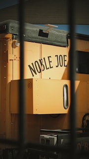 Yellow train car with "noble joe" painted on side.