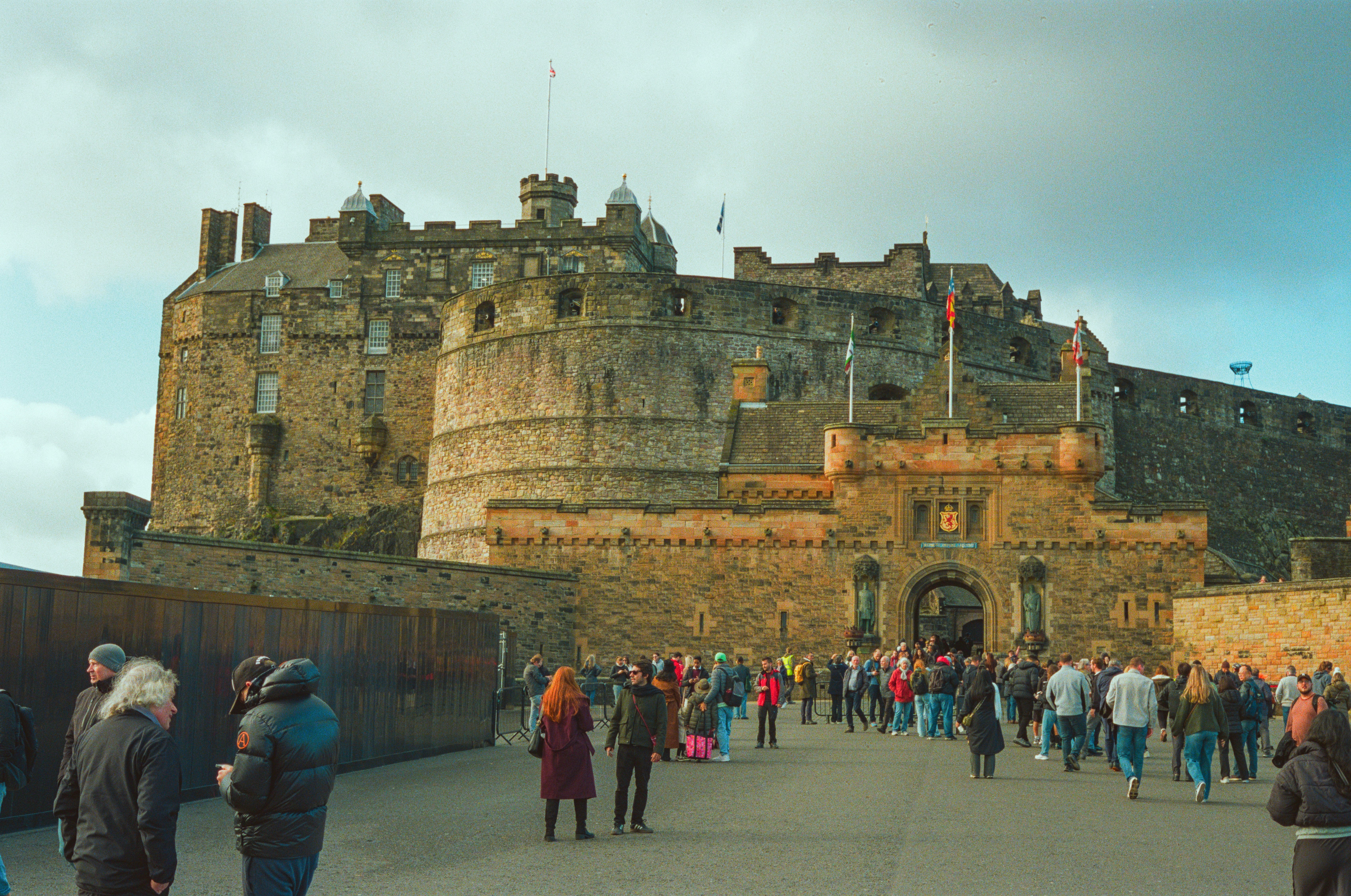 People walking towards a large historic castle entrance
