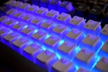 Close-up of a white keyboard with blue backlighting.