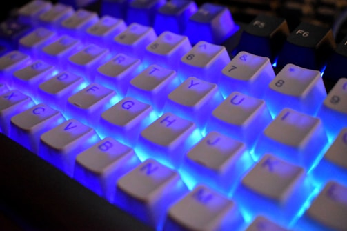 Close-up of a white keyboard with blue backlighting.