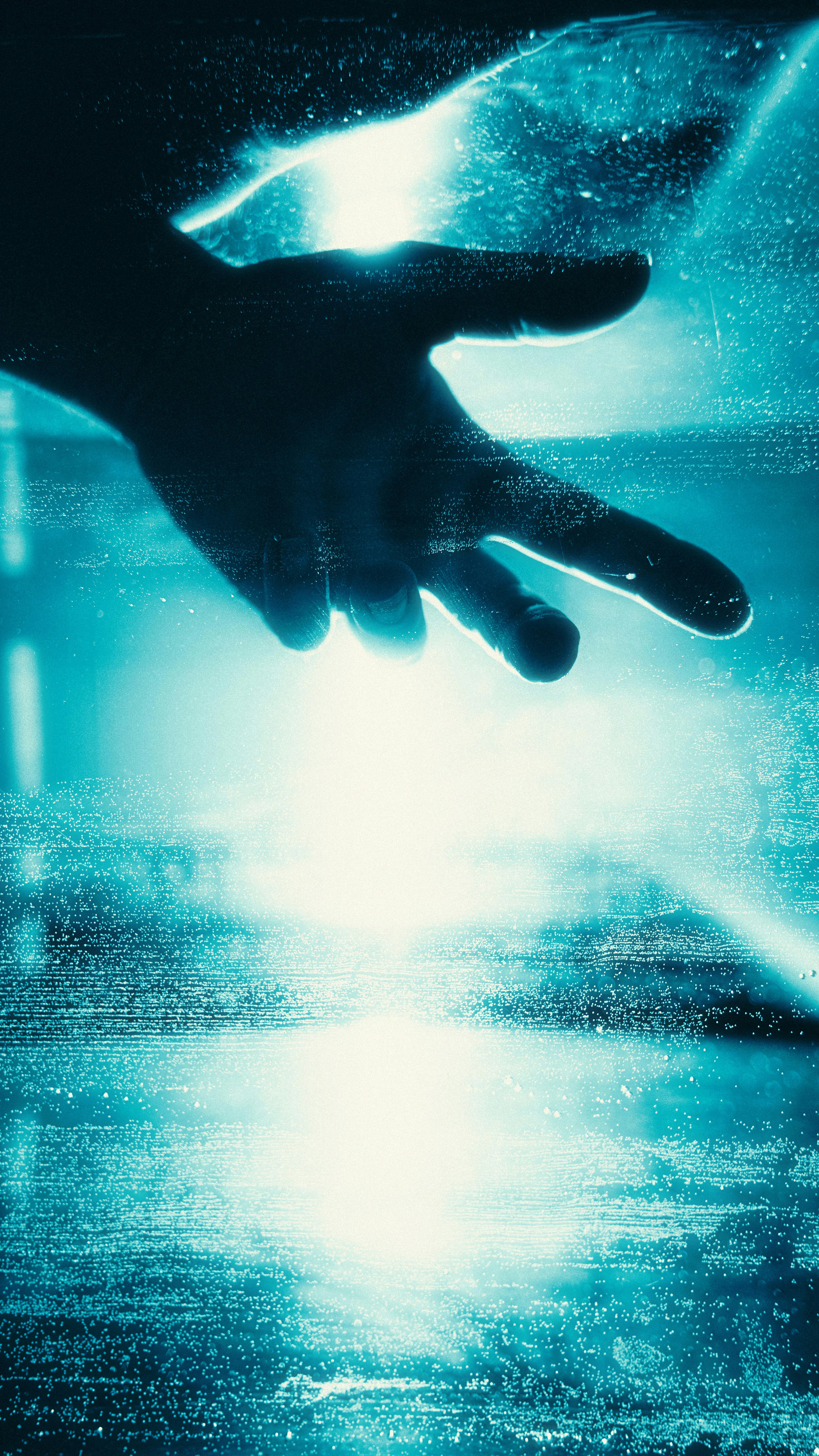 A hand reaches out in a bright blue abstract background