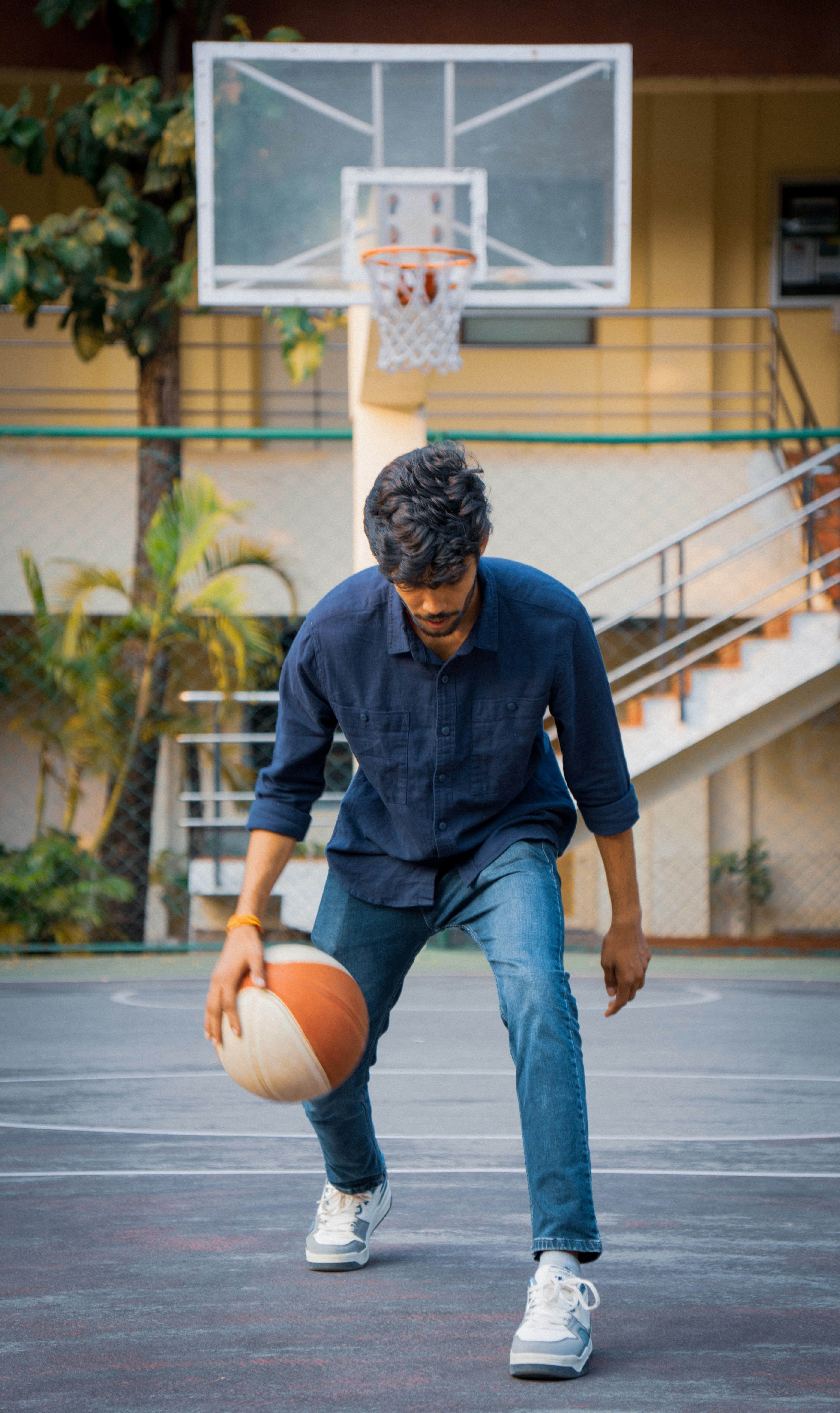 Mann dribbelt Basketball auf dem Spielfeld in der Nähe des Spielfelds