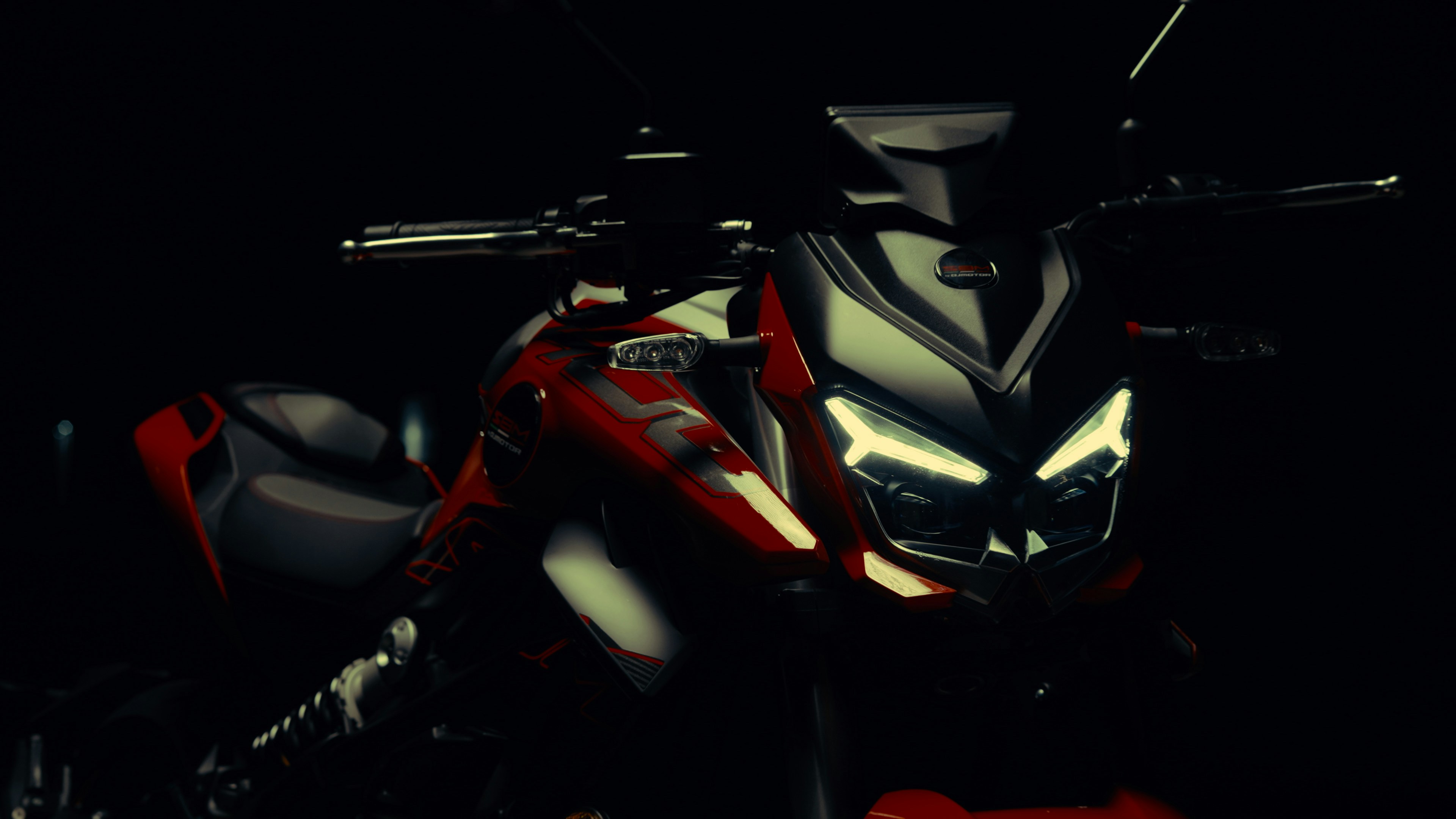 Red motorcycle with sharp headlights in darkness