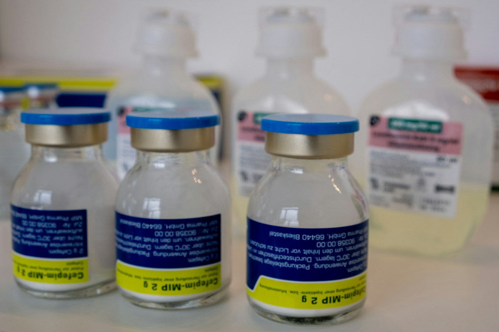 Several unlabeled medical vials and bottles on a shelf, the kind sold as research peptides