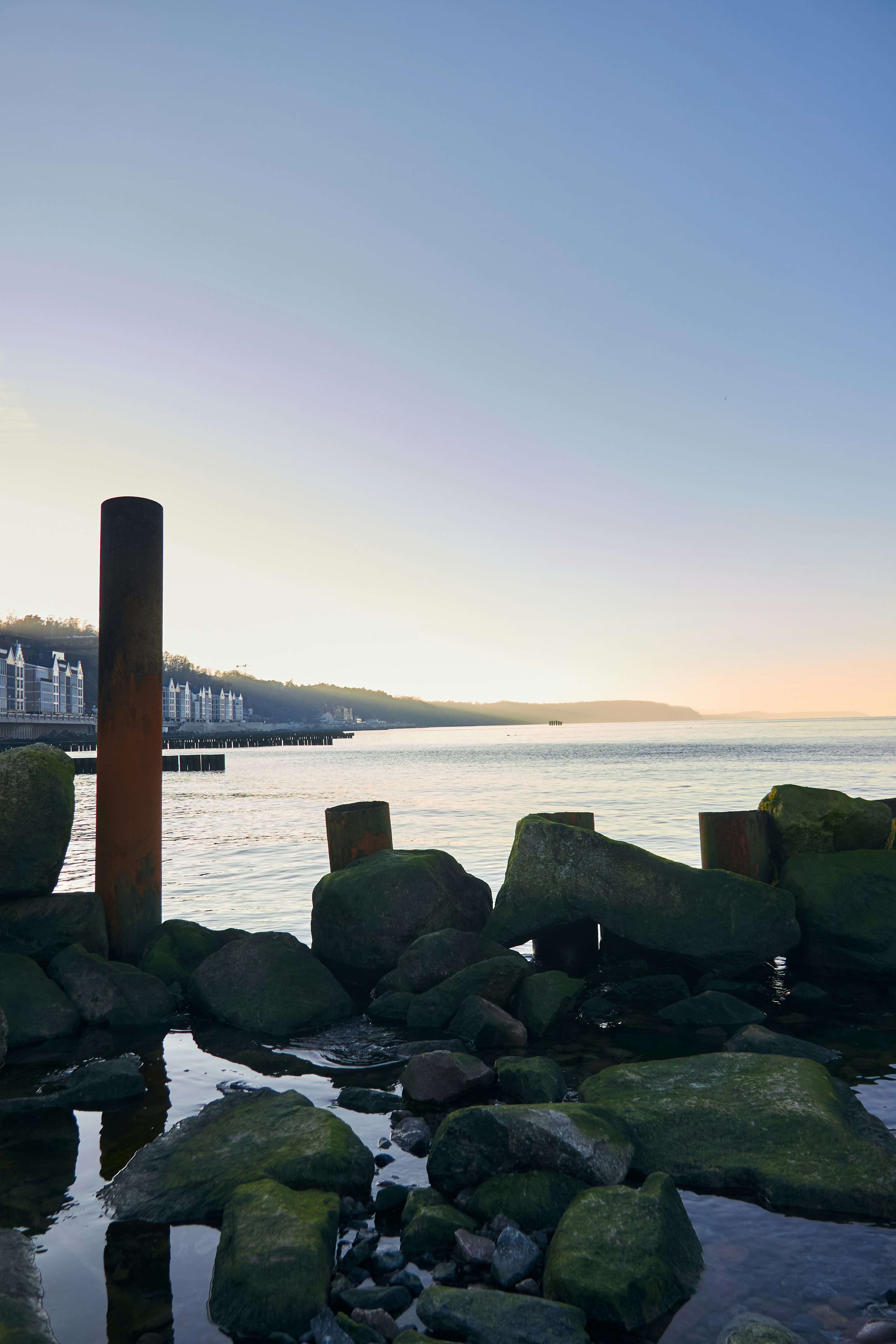 Rocky shore with buildings along the coast at sunset