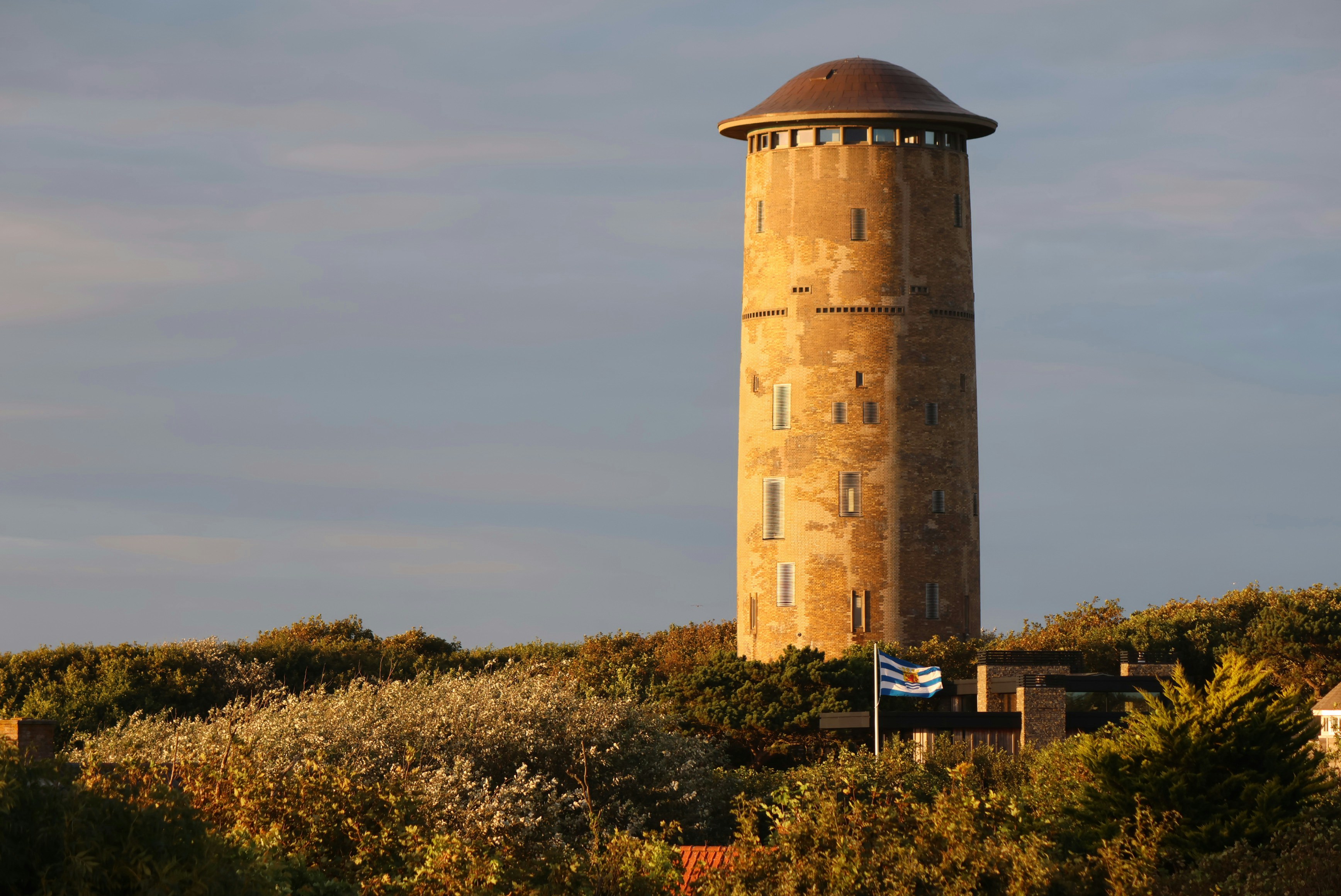 A tall concrete water tower on a hill.