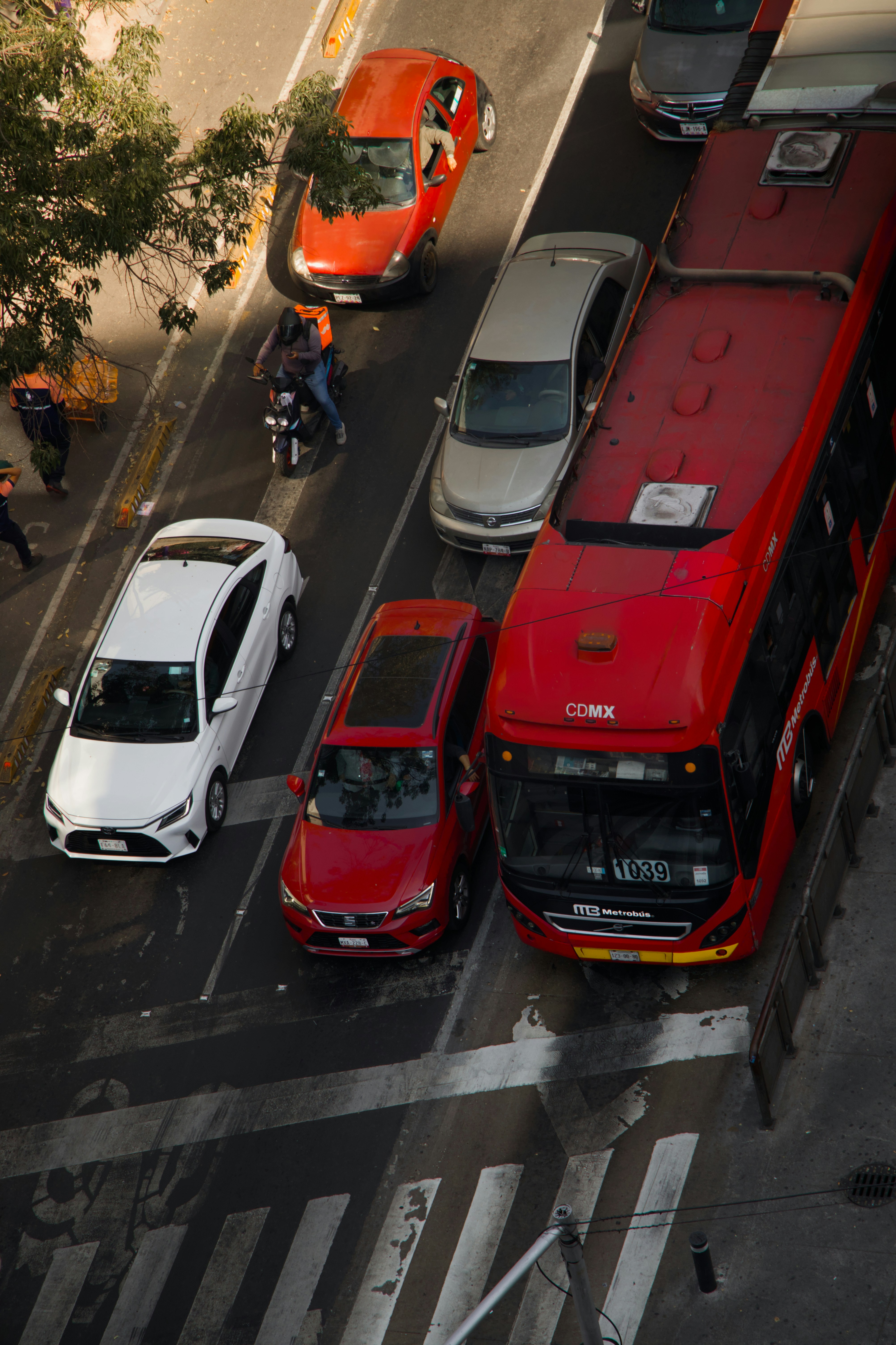 Autobús rojo y coches en el tráfico de la calle de la ciudad