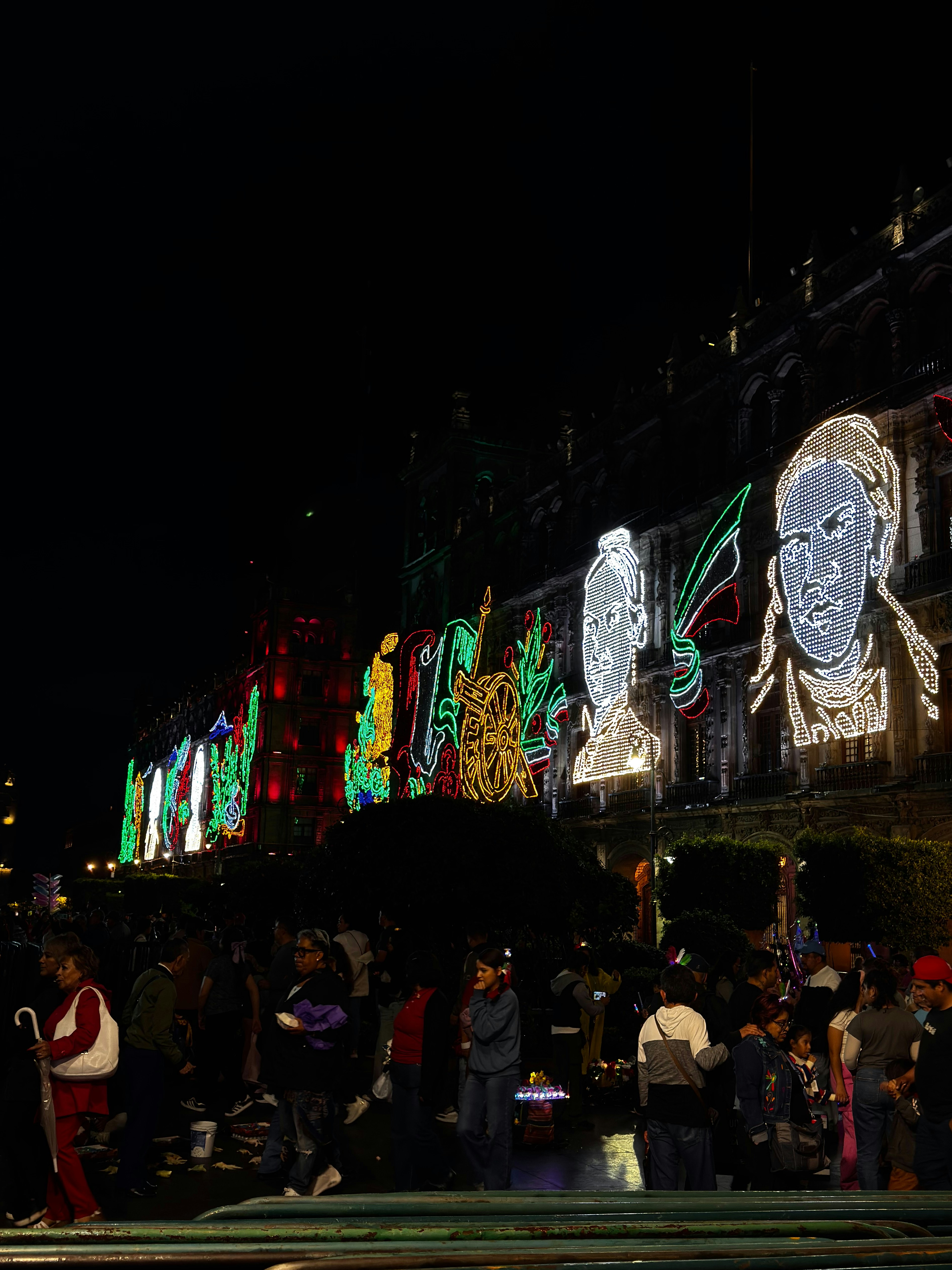Edificio iluminado con luces coloridas y retratos por la noche.