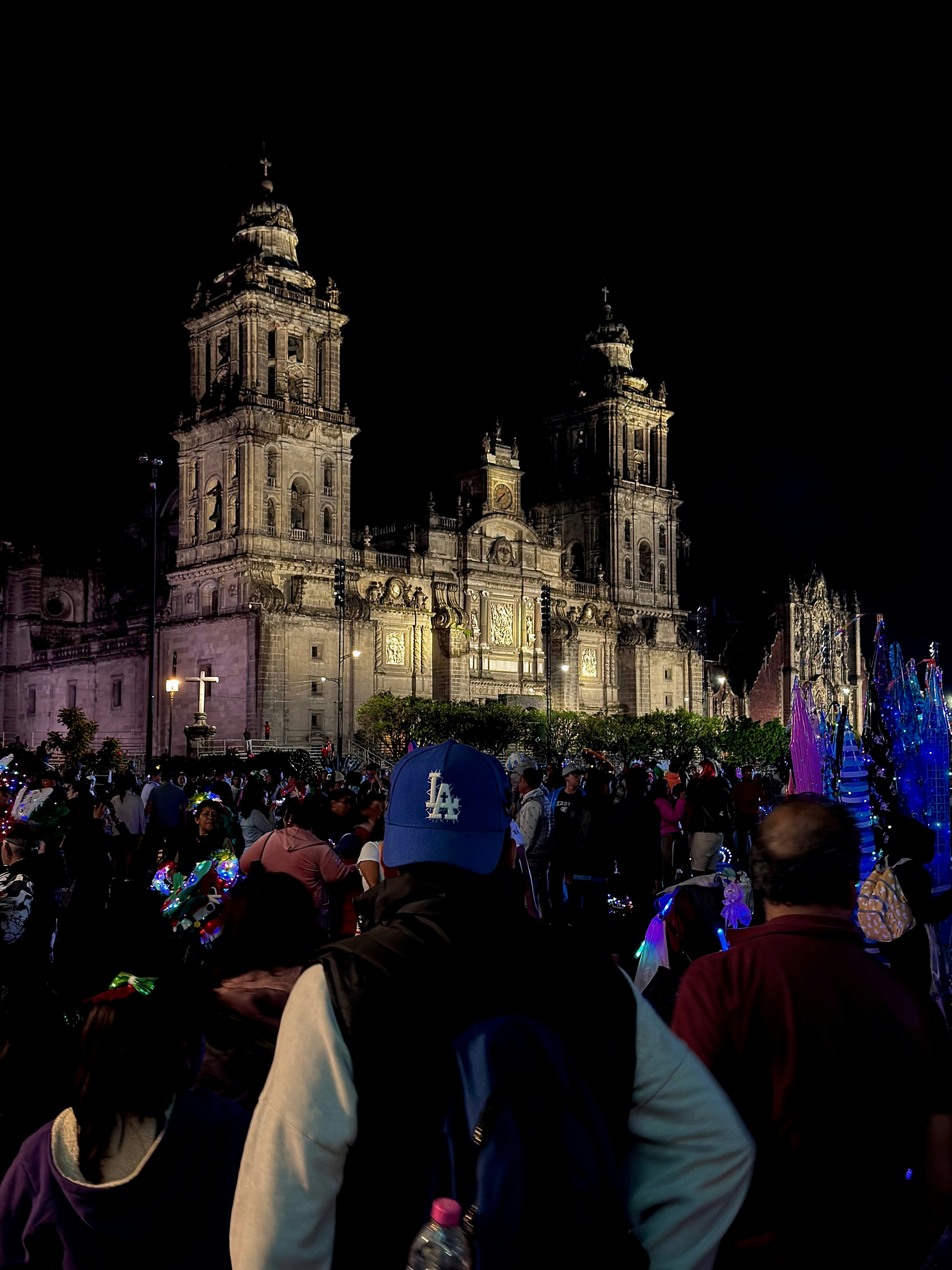 La multitud se reúne frente a la catedral iluminada por la noche