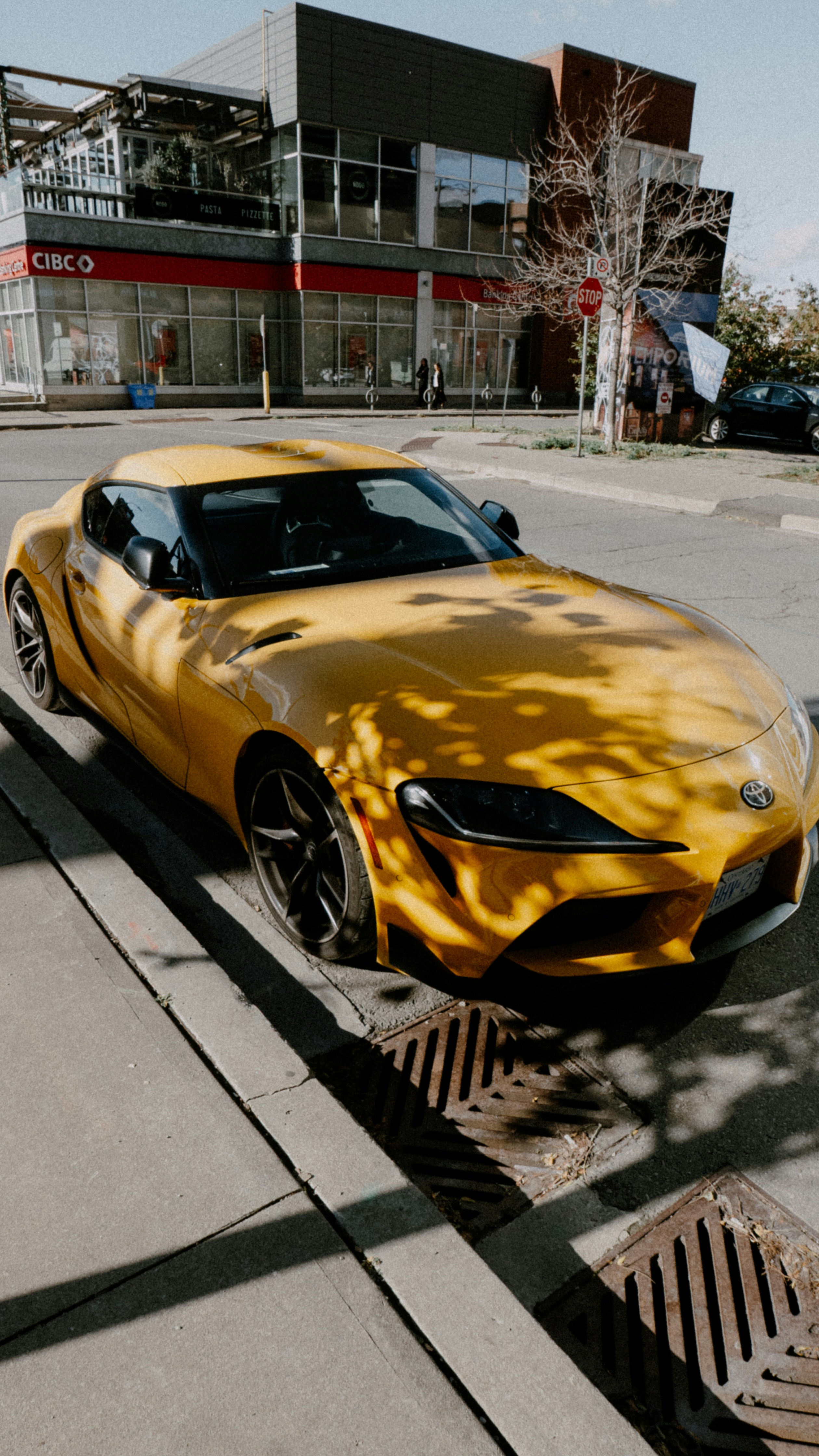 Coche deportivo amarillo aparcado en una calle de la ciudad.