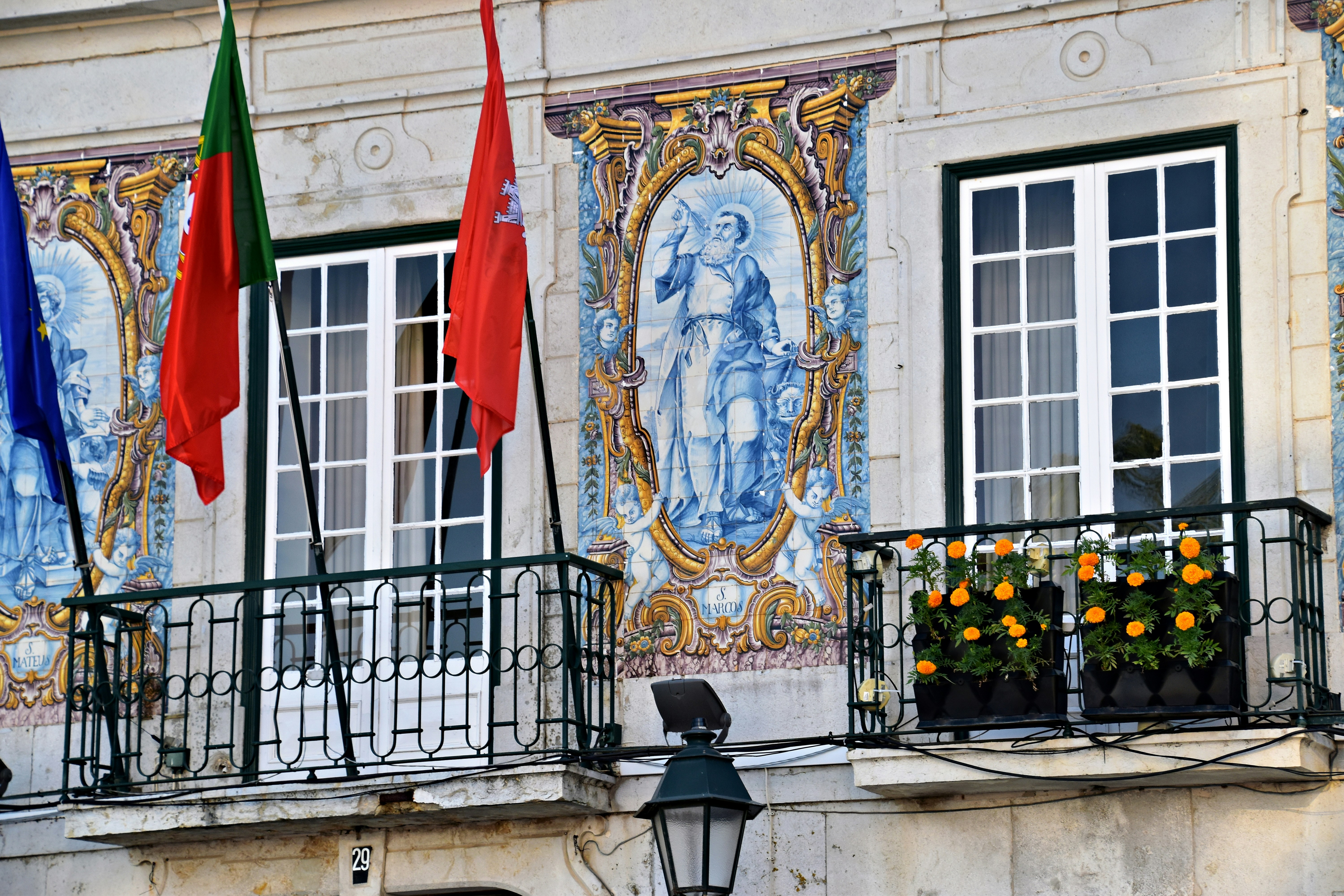Building facade with flags and tiled artwork