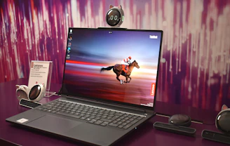 Laptop displaying a horse racing on its screen.