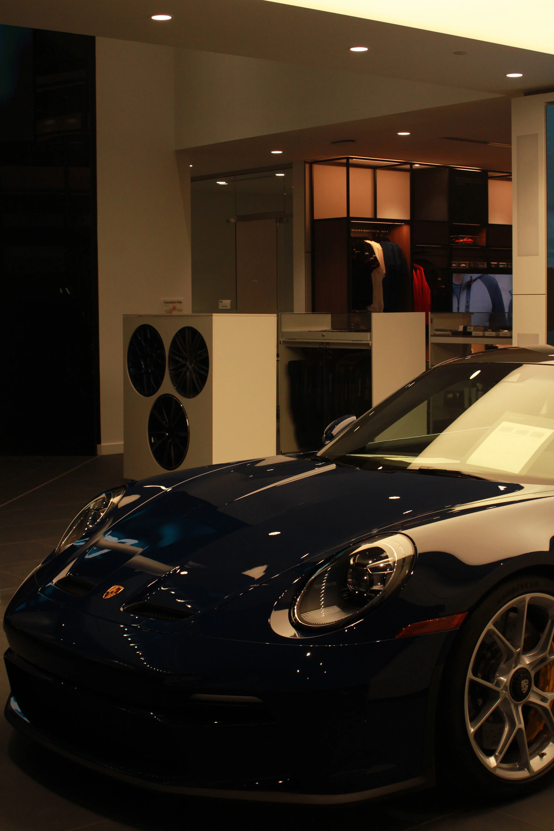 A dark blue sports car in a showroom.