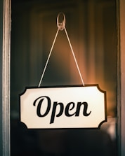 A white 'open' sign hanging on a door.