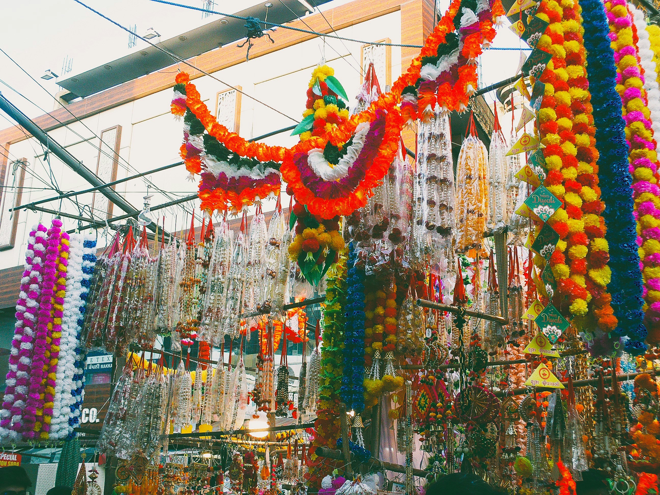 Colorful garlands and decorations hanging at a market.