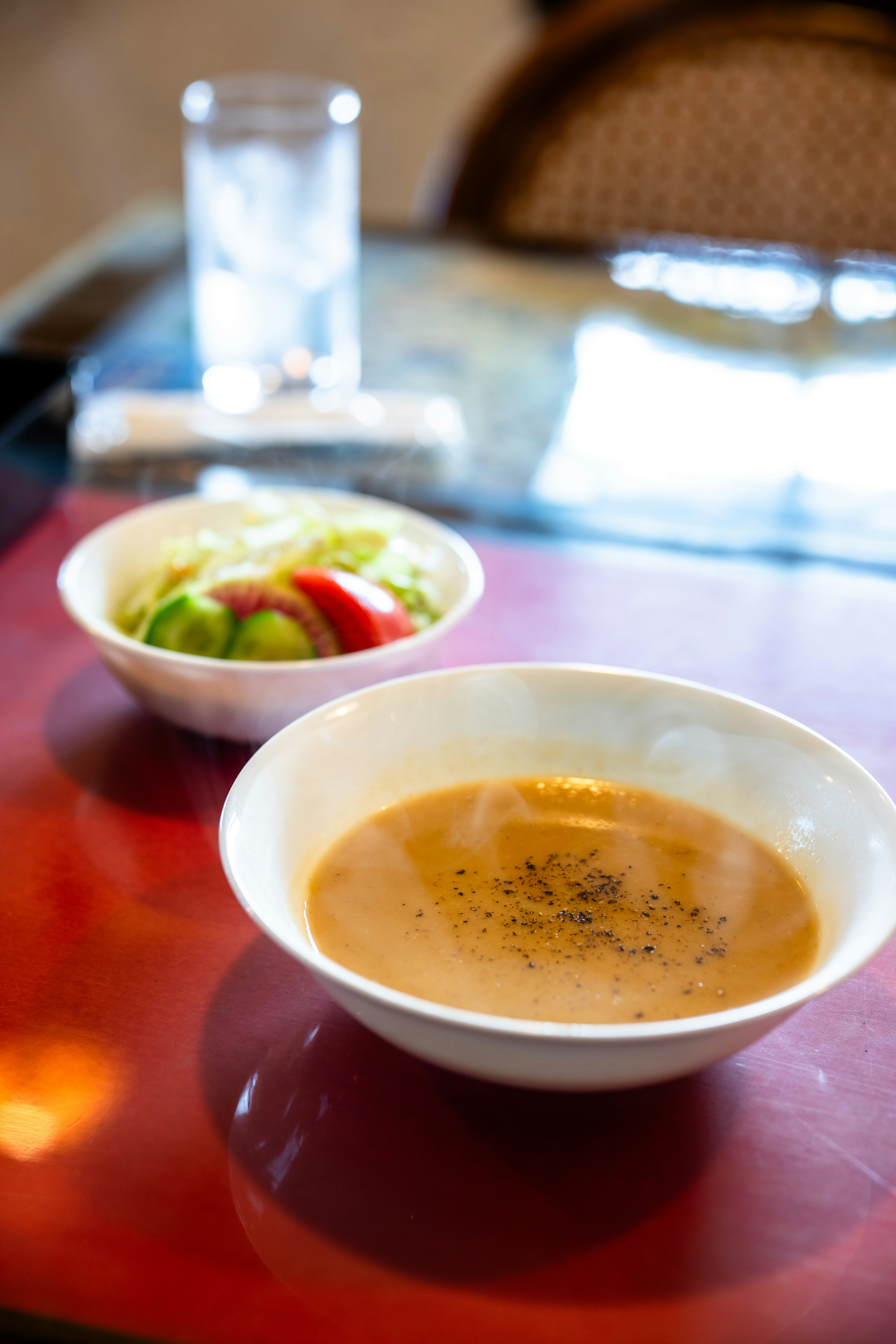 Bowl of soup and salad with a glass of water