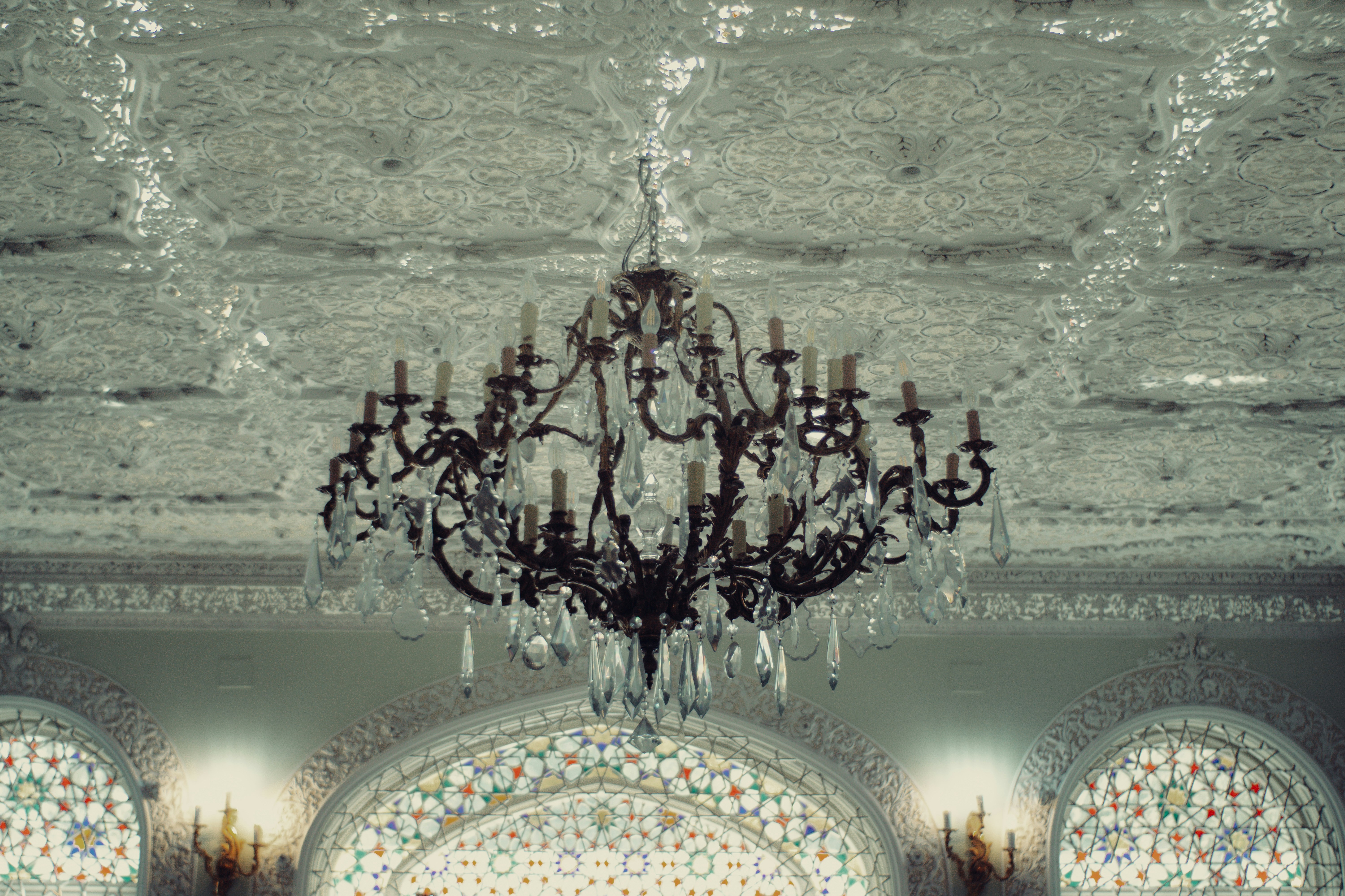 Ornate chandelier hanging from a decorative ceiling.